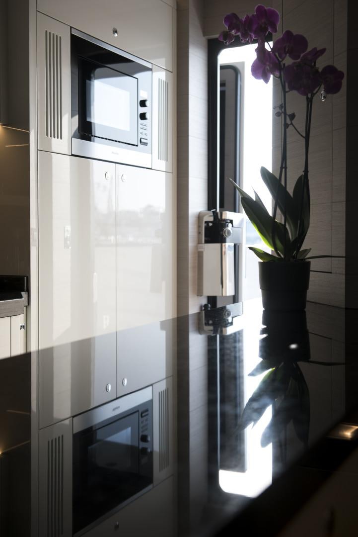 a kitchen with a glass door aboard ALFRESCO 125 Yacht for Sale