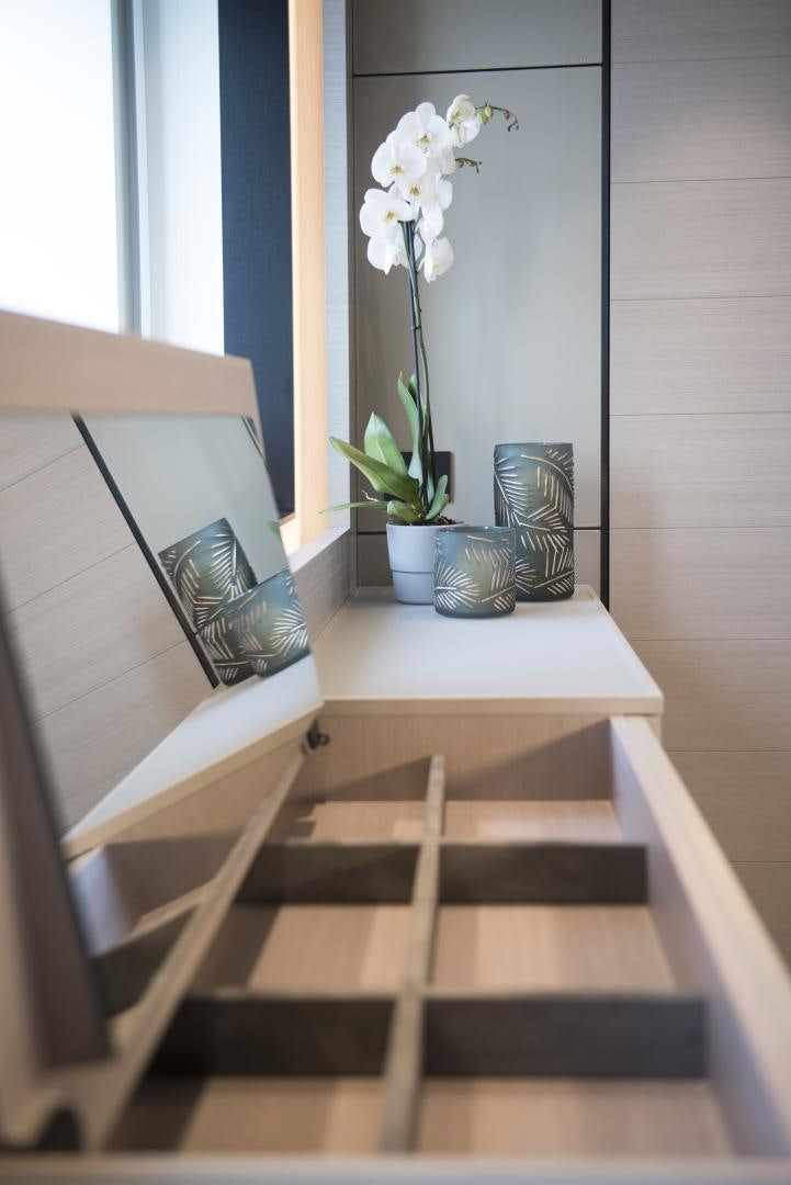 a desk with a laptop and flowers aboard ALFRESCO 125 Yacht for Sale