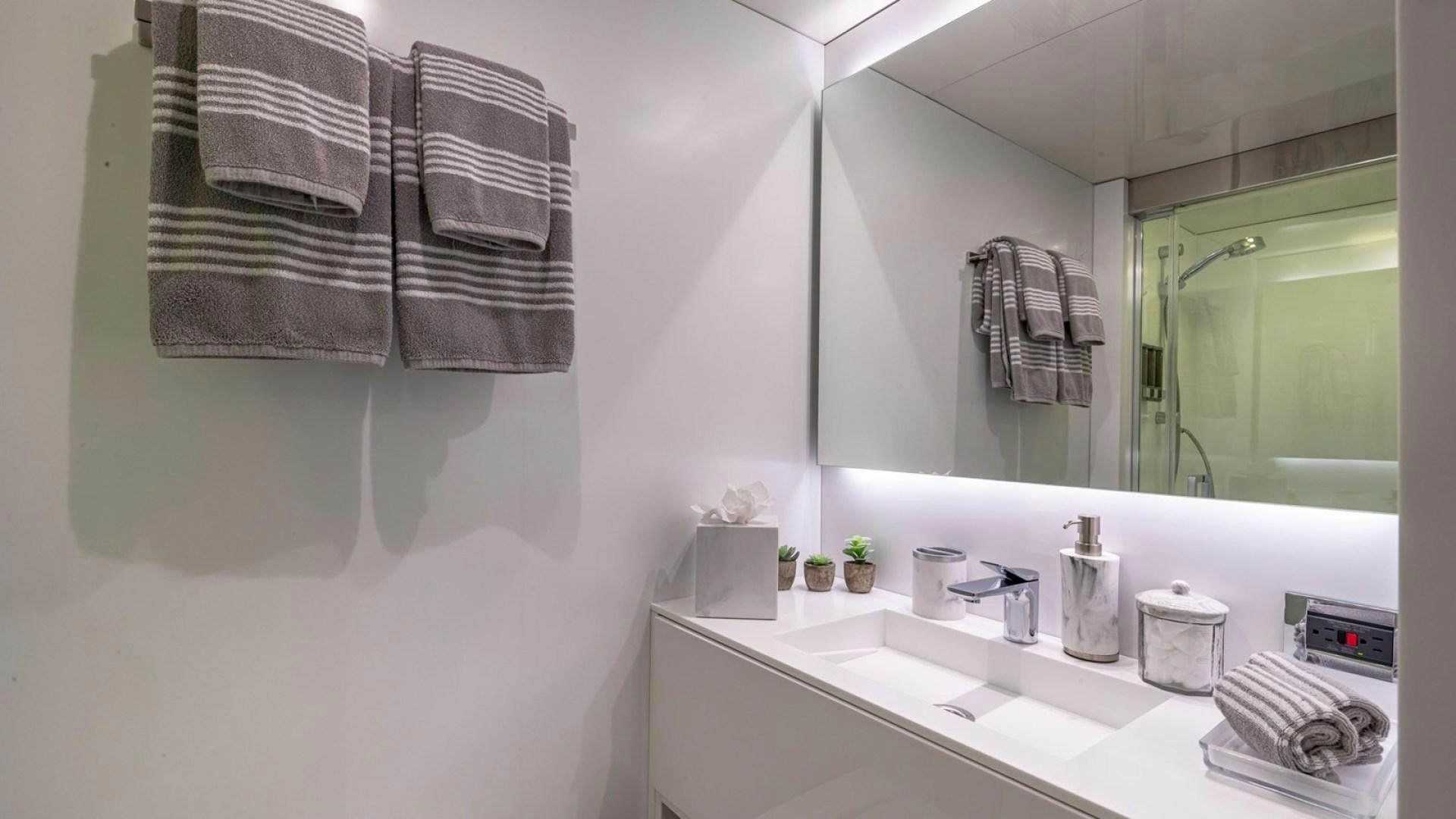 a bathroom with towels and a mirror aboard OCULUS Yacht for Sale
