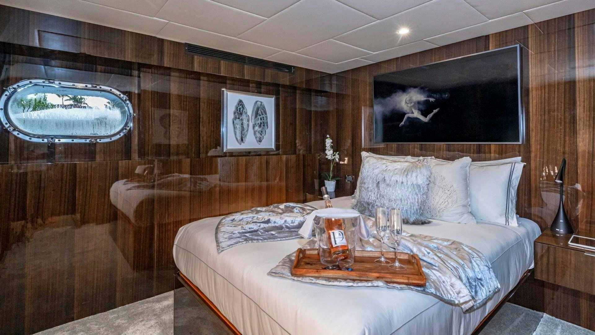 a room with a bed and a television aboard OCULUS Yacht for Sale