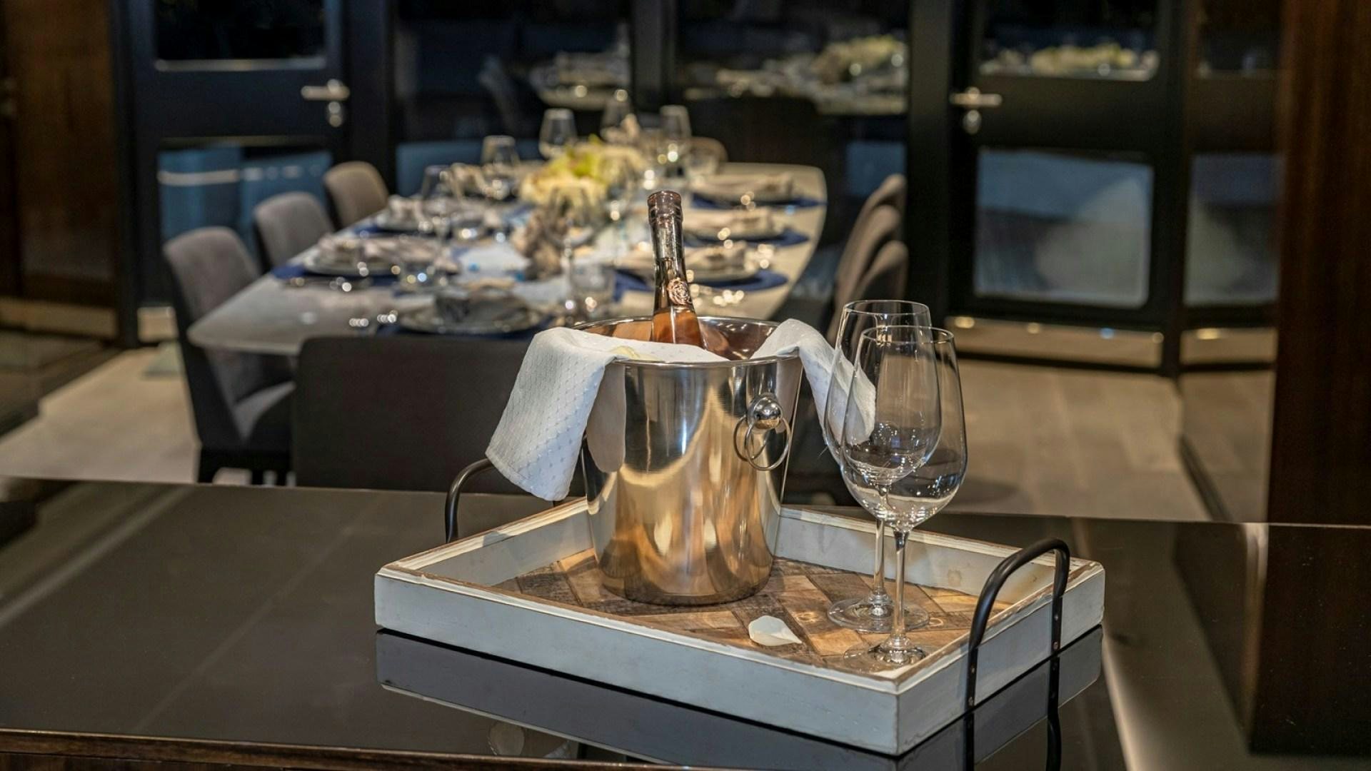 a table with a glass and a vase with flowers on it aboard OCULUS Yacht for Sale