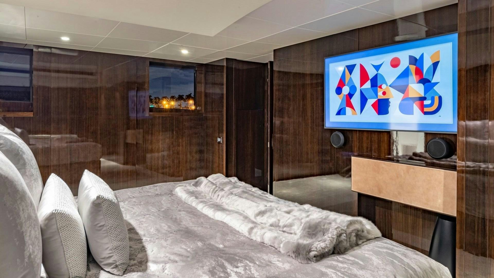 a room with a bed and a television aboard OCULUS Yacht for Sale