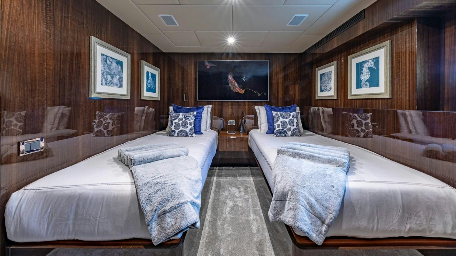 a room with beds and a tv aboard OCULUS Yacht for Sale