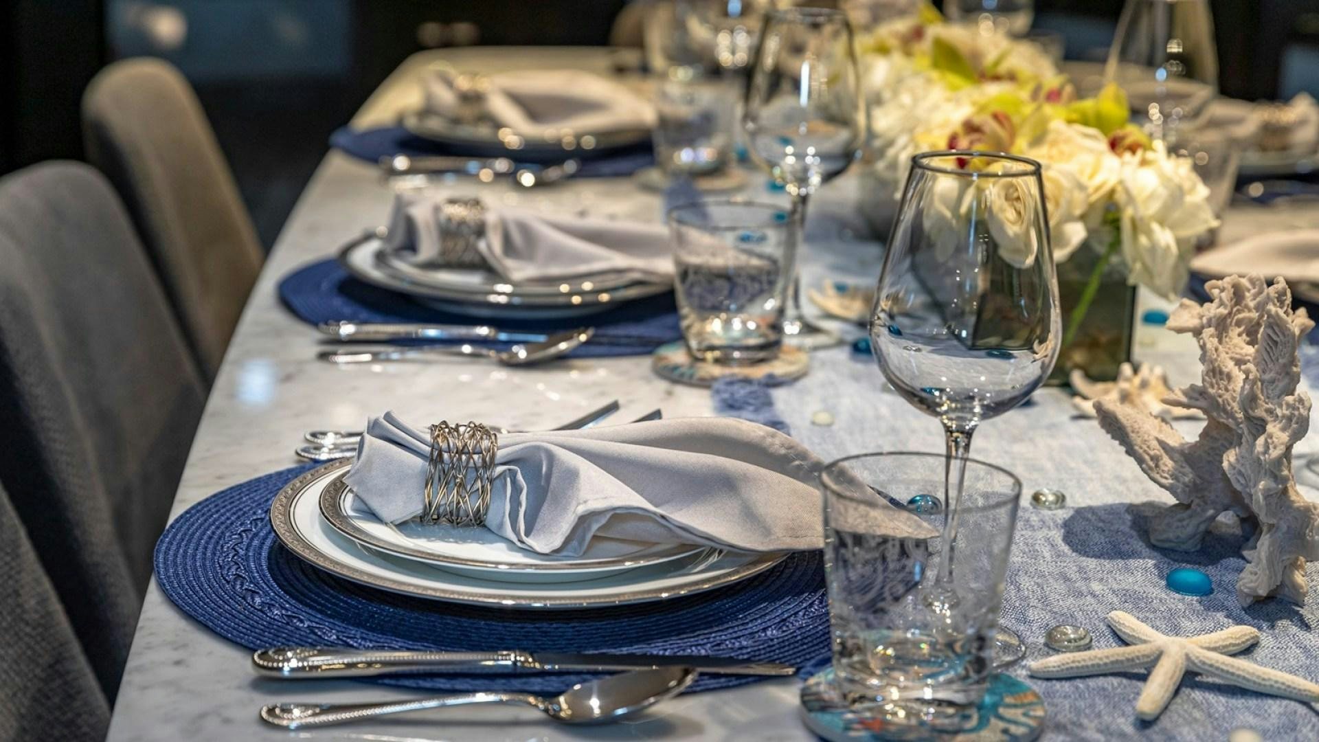 a table with plates and glasses aboard OCULUS Yacht for Sale