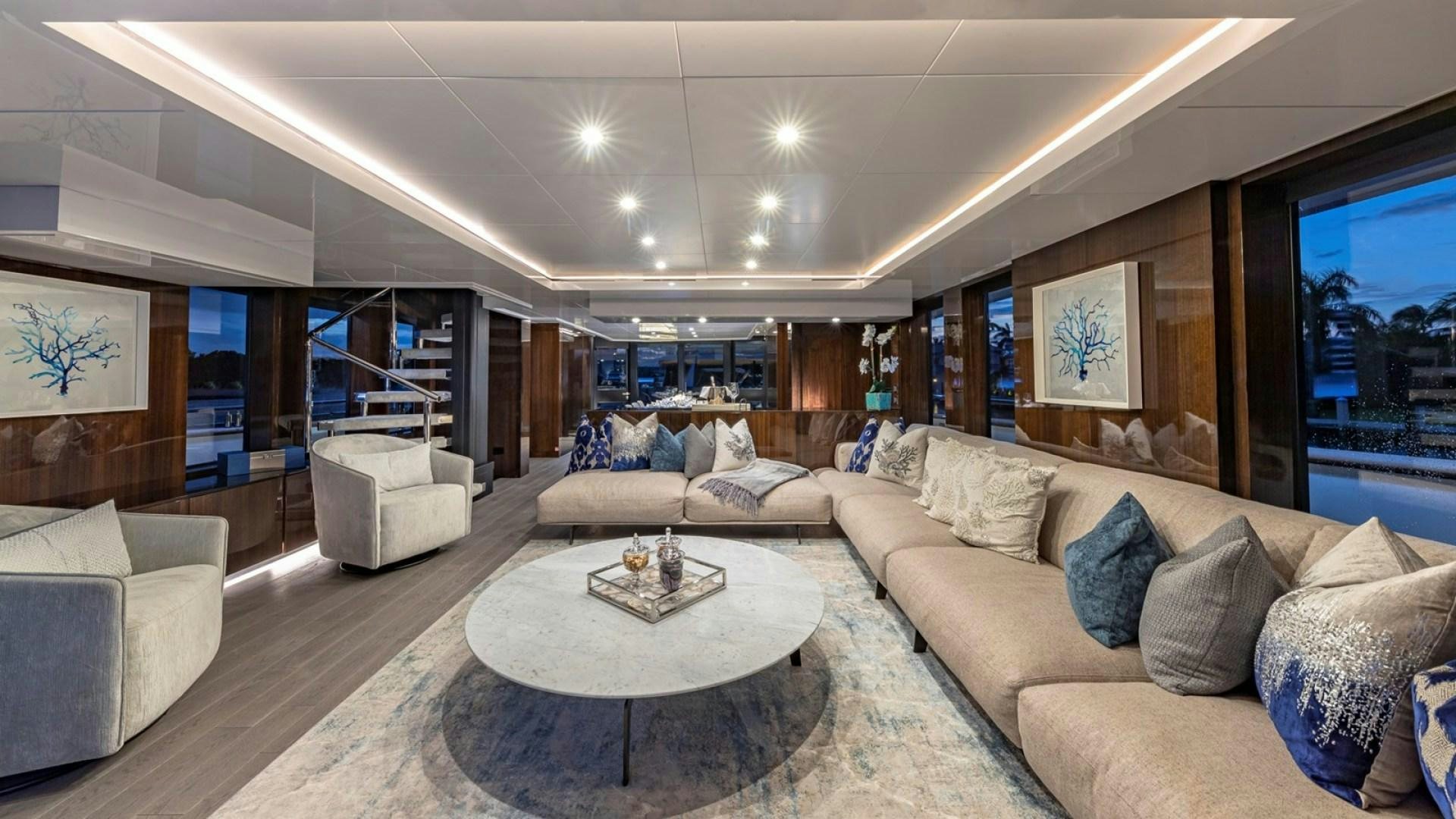a living room with a large sofa and a coffee table aboard OCULUS Yacht for Sale