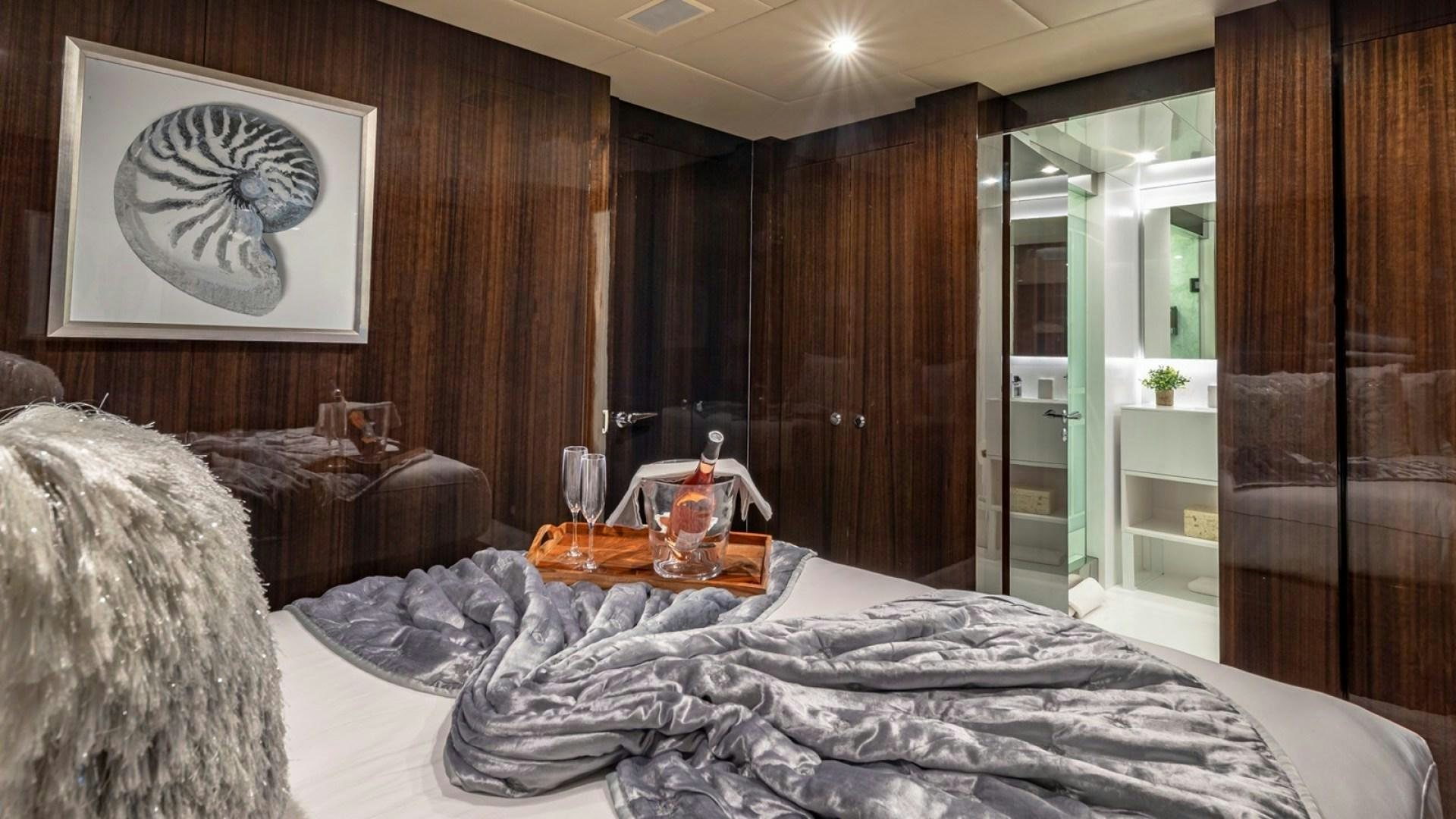 a bed with a glass of tea on it aboard OCULUS Yacht for Sale