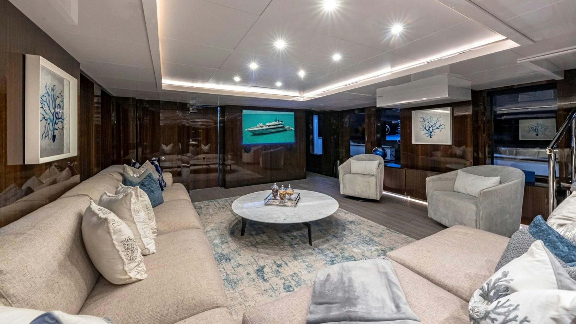 a living room with a large screen aboard OCULUS Yacht for Sale