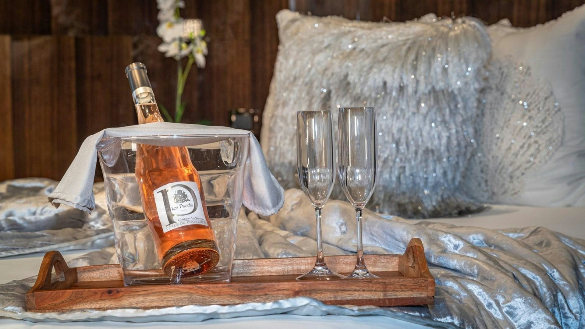 a bottle of liquor and a glass on a table aboard OCULUS Yacht for Sale