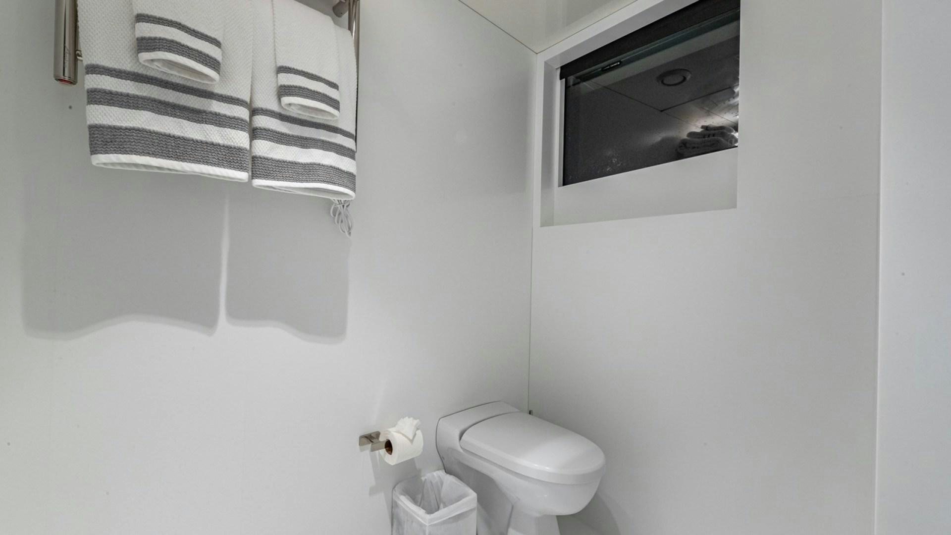 a bathroom with a toilet and towels aboard OCULUS Yacht for Sale