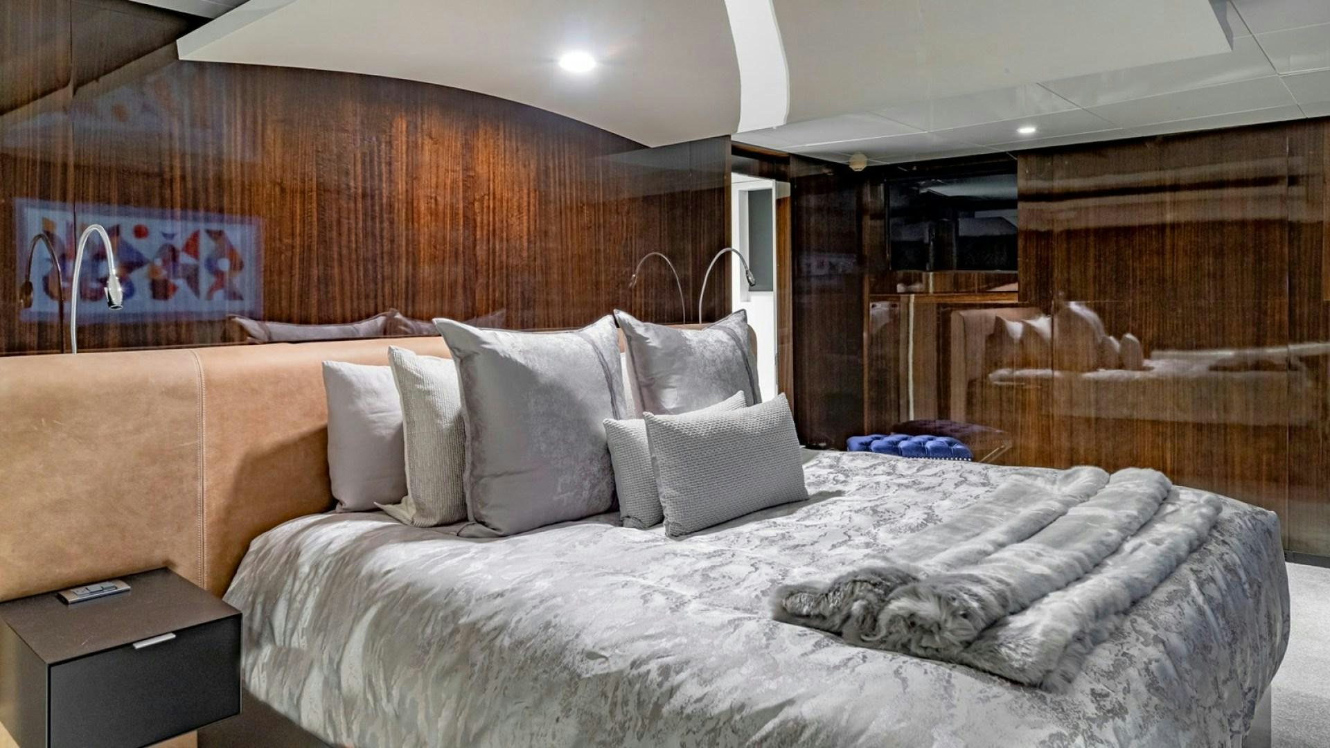 a bed with a white comforter and pillows aboard OCULUS Yacht for Sale