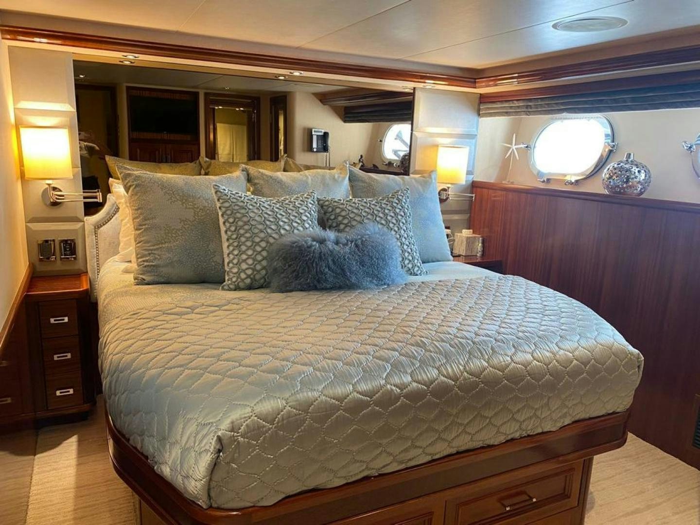 a bed with a blue comforter aboard YES Yacht for Sale