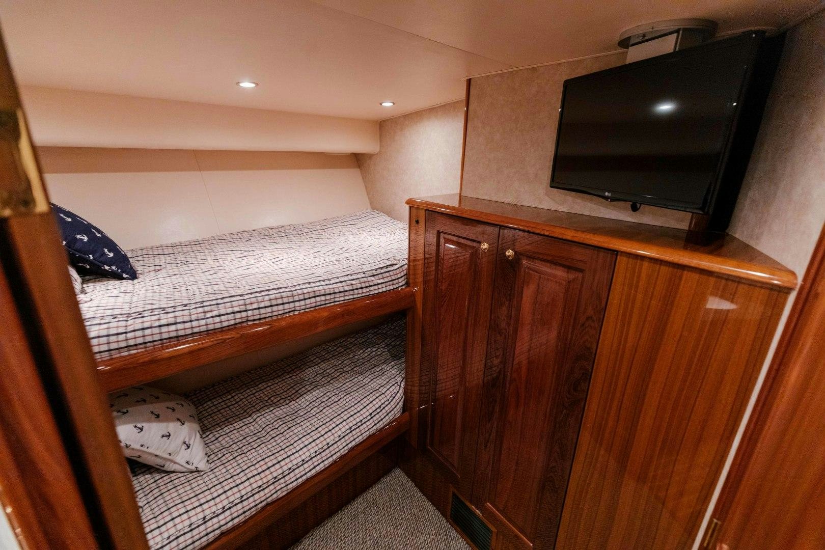 a bedroom with a tv and a dresser aboard KICKBACK Yacht for Sale