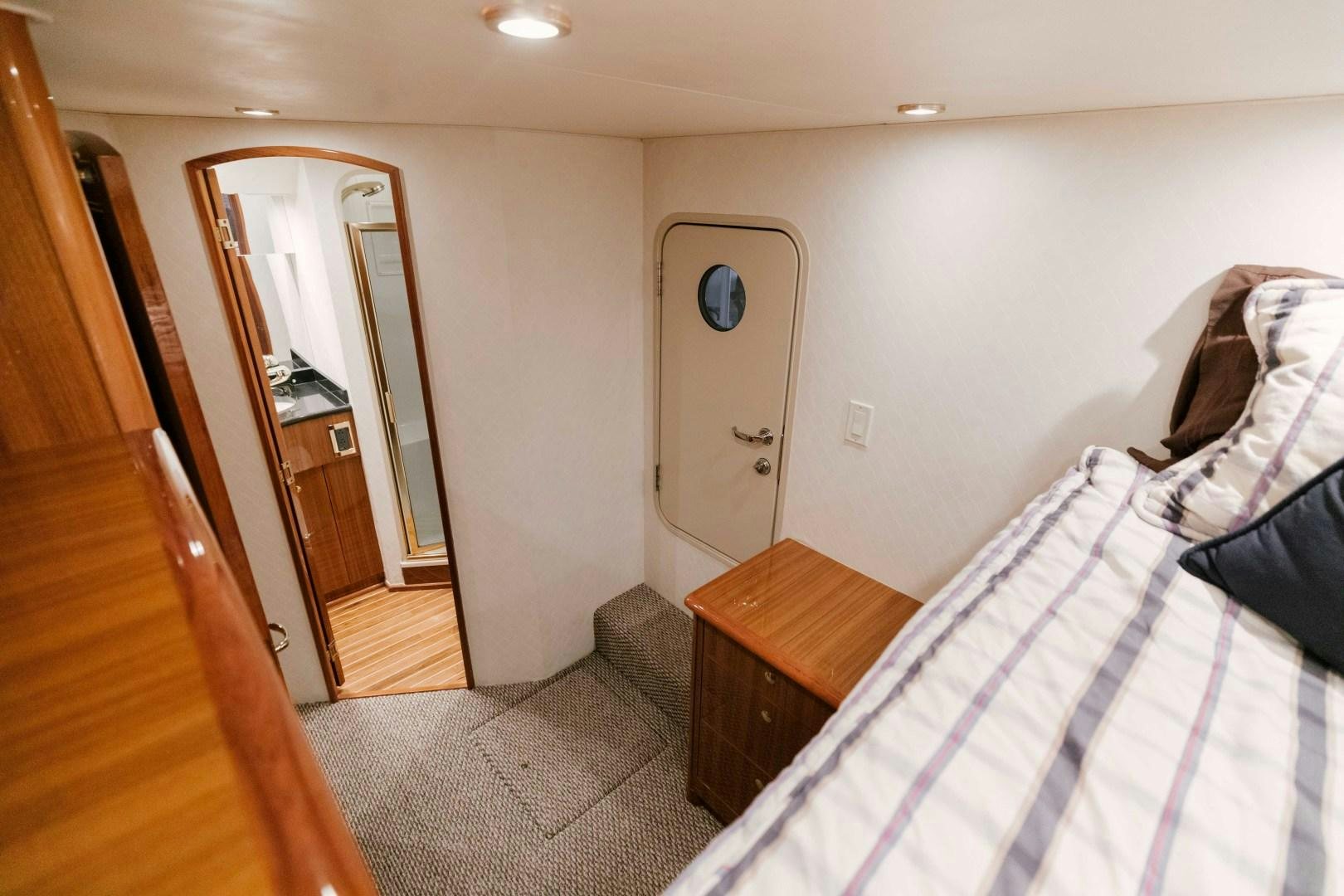 a bedroom with a bed and a closet aboard KICKBACK Yacht for Sale