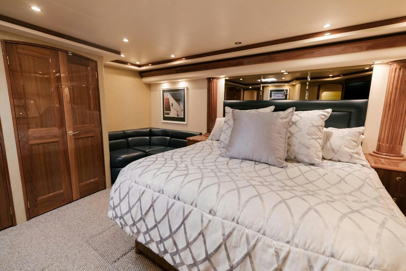 a bed with a white sheet and pillows aboard KICKBACK Yacht for Sale