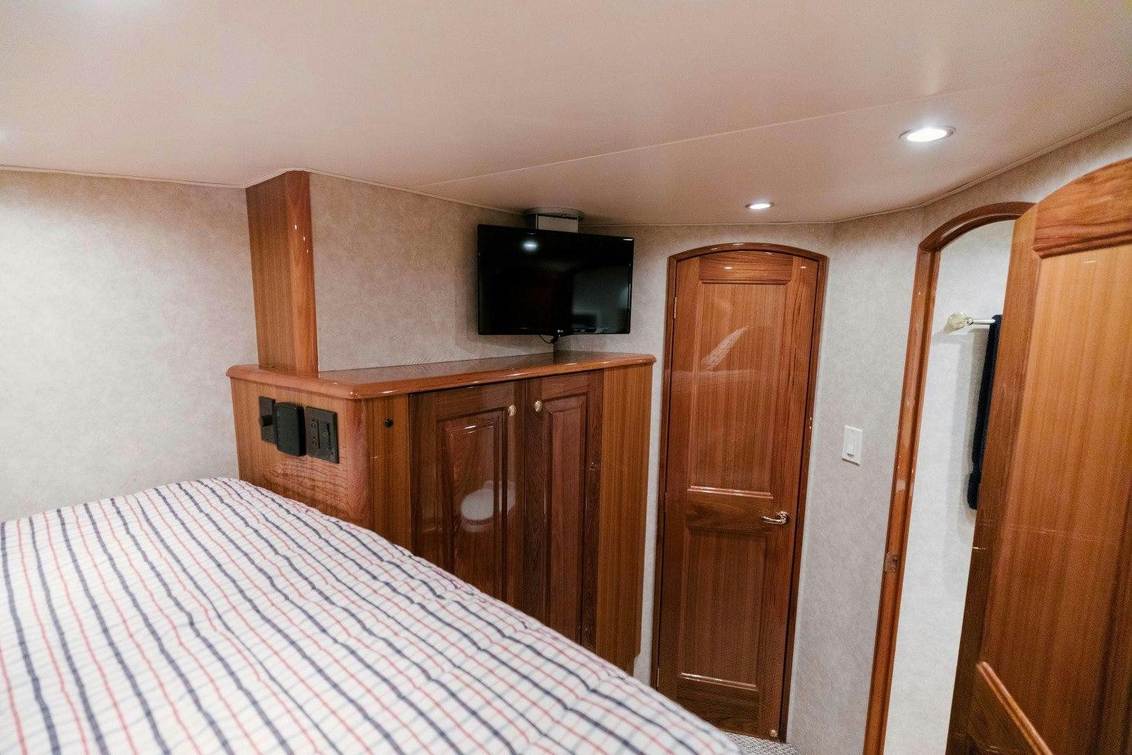 a bedroom with a bed and a television aboard KICKBACK Yacht for Sale