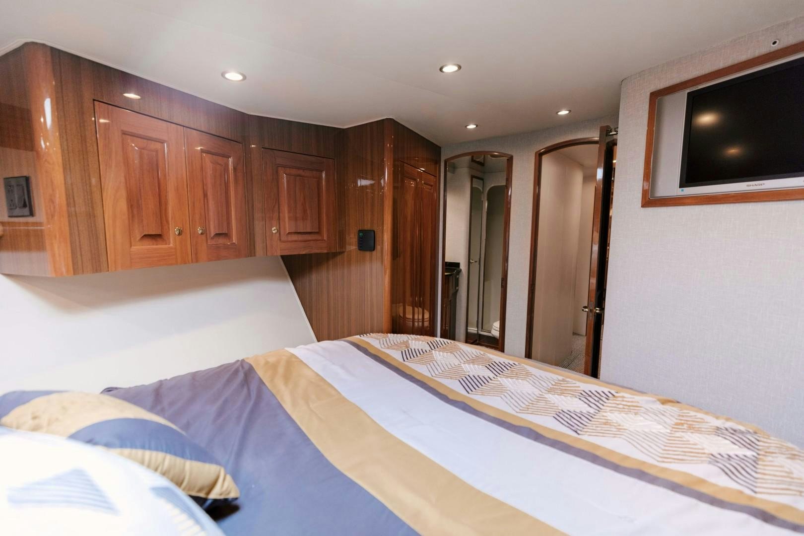 a bedroom with a bed and a television aboard KICKBACK Yacht for Sale