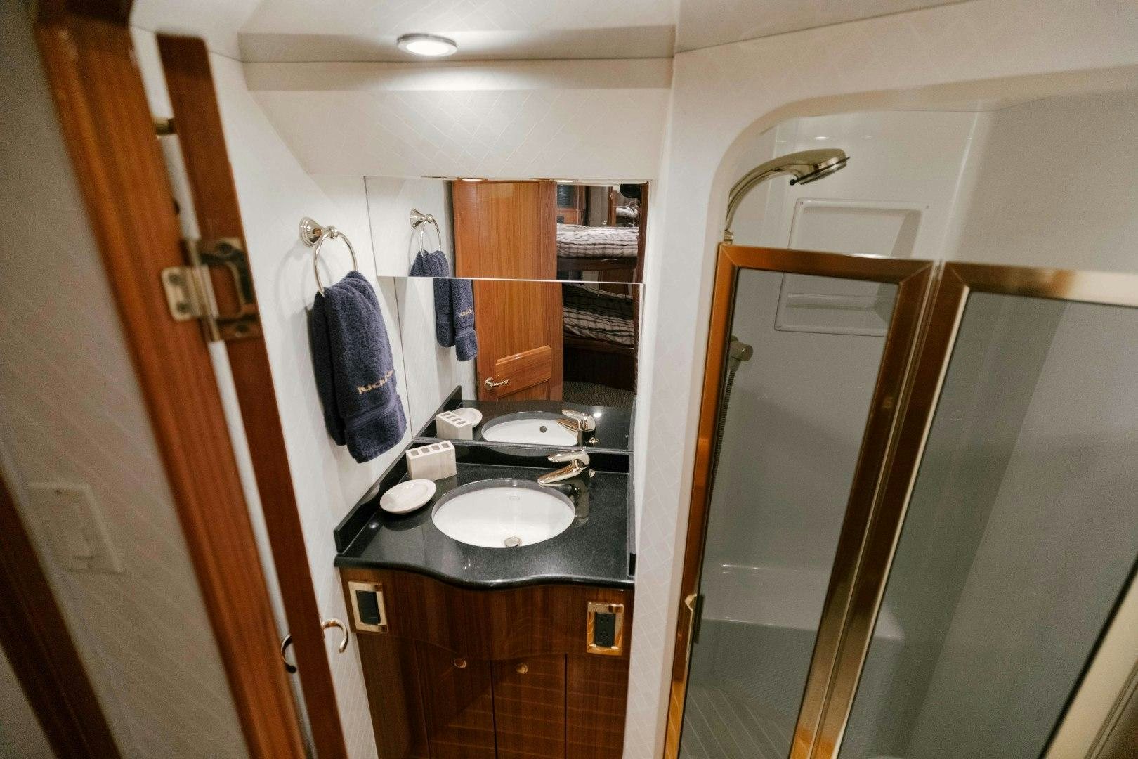 a bathroom with a sink and a mirror aboard KICKBACK Yacht for Sale