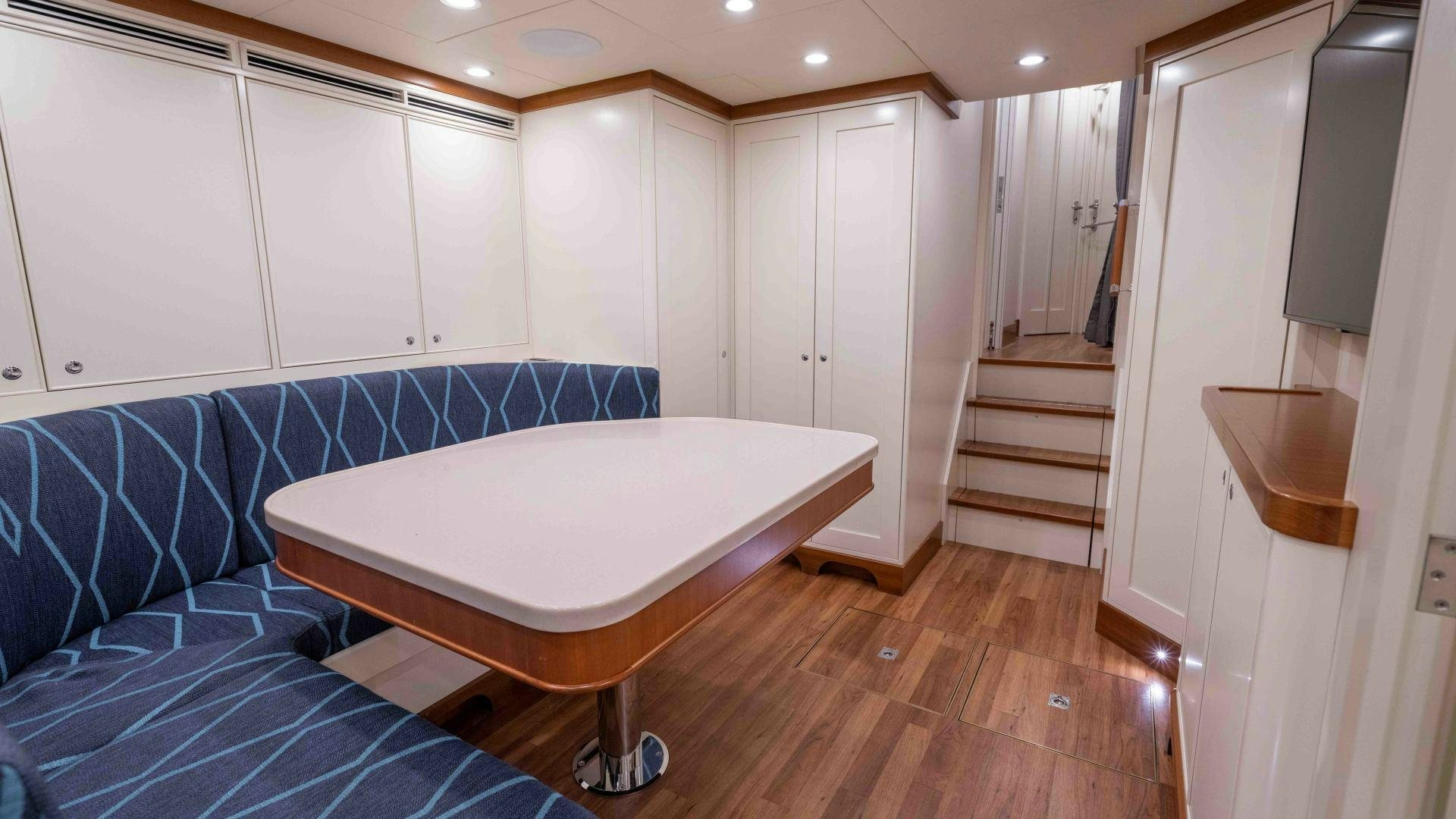 a large white oval table in a room with white cabinets aboard NEREUS Yacht for Sale