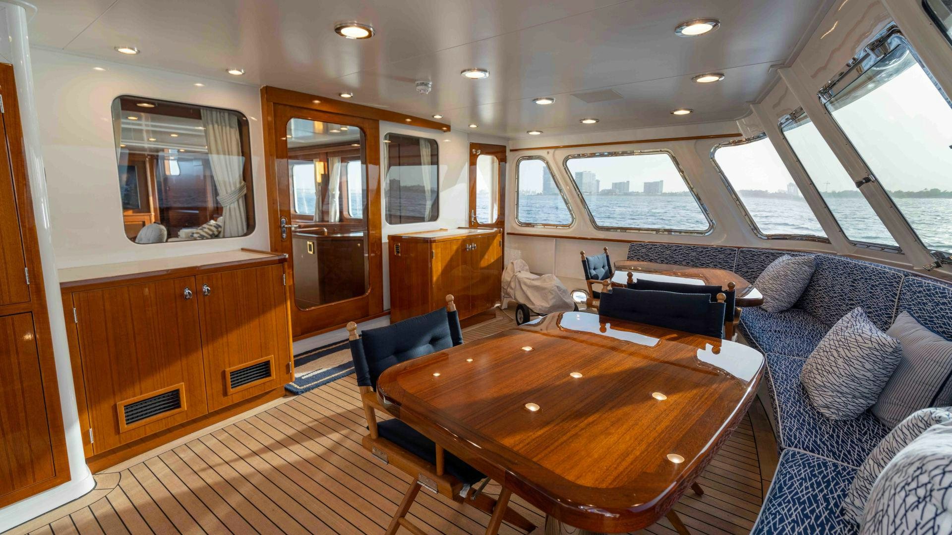 a living room with a table and chairs aboard NEREUS Yacht for Sale