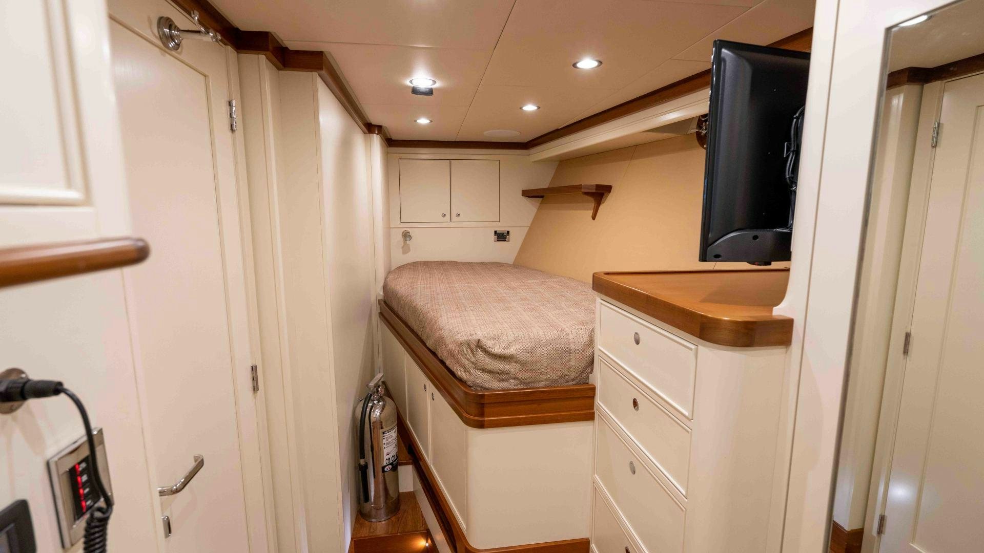 a bedroom with a bed and a television aboard NEREUS Yacht for Sale