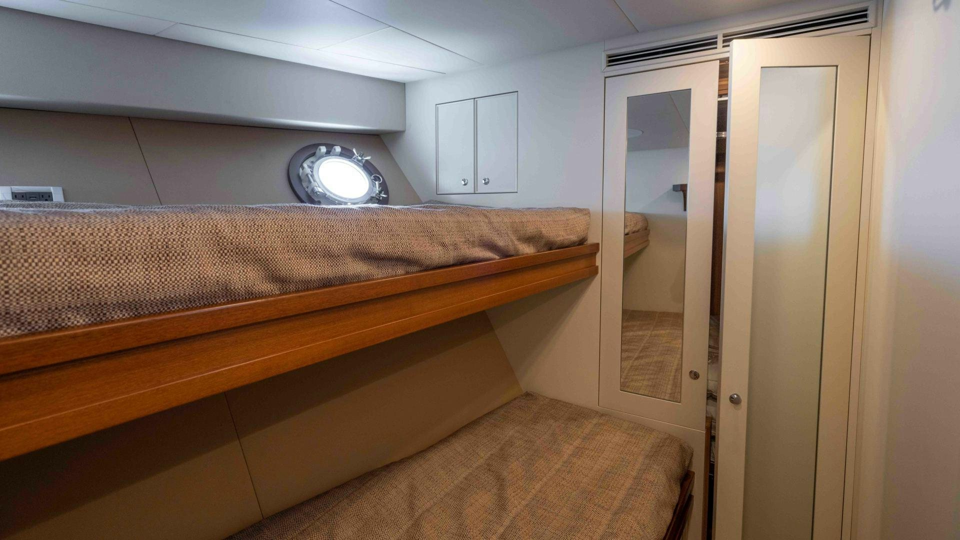 a bed with a round light aboard NEREUS Yacht for Sale