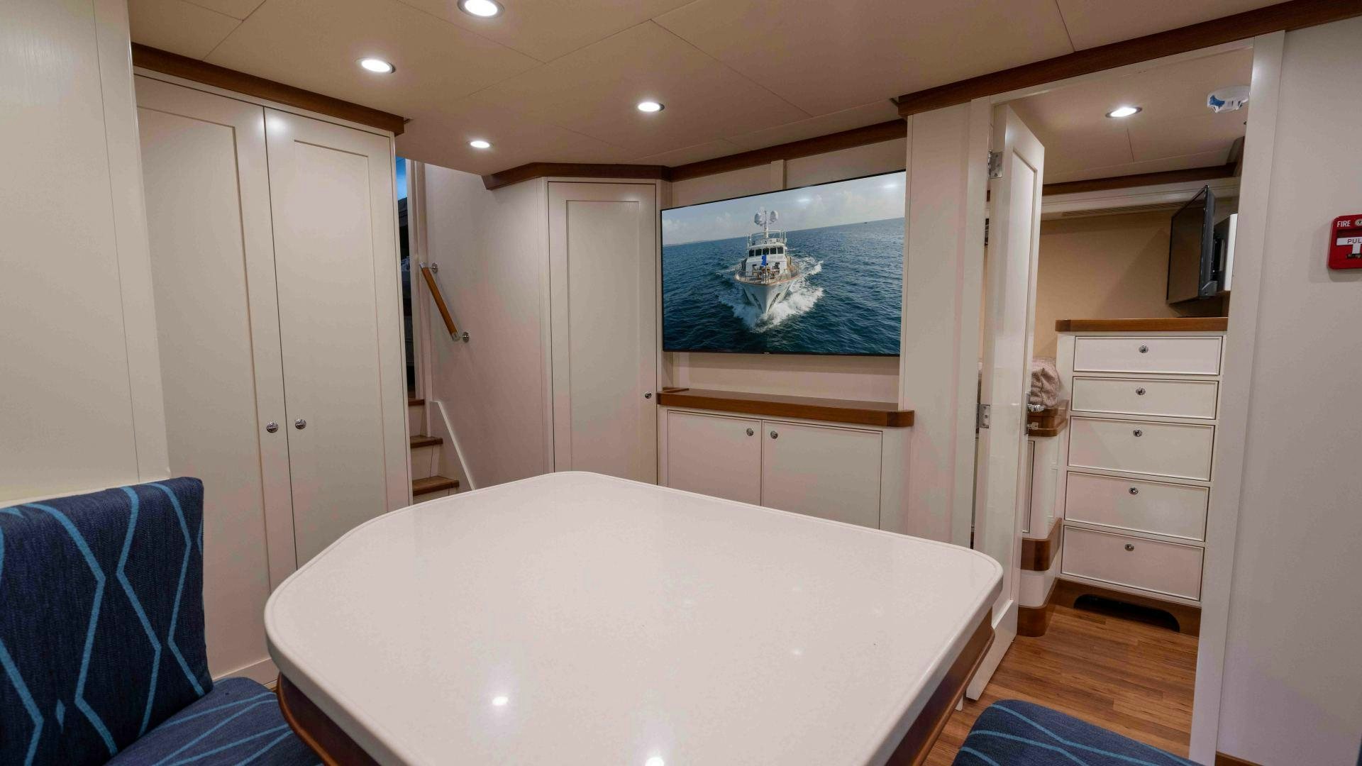 a room with a large white table and a large white bed aboard NEREUS Yacht for Sale