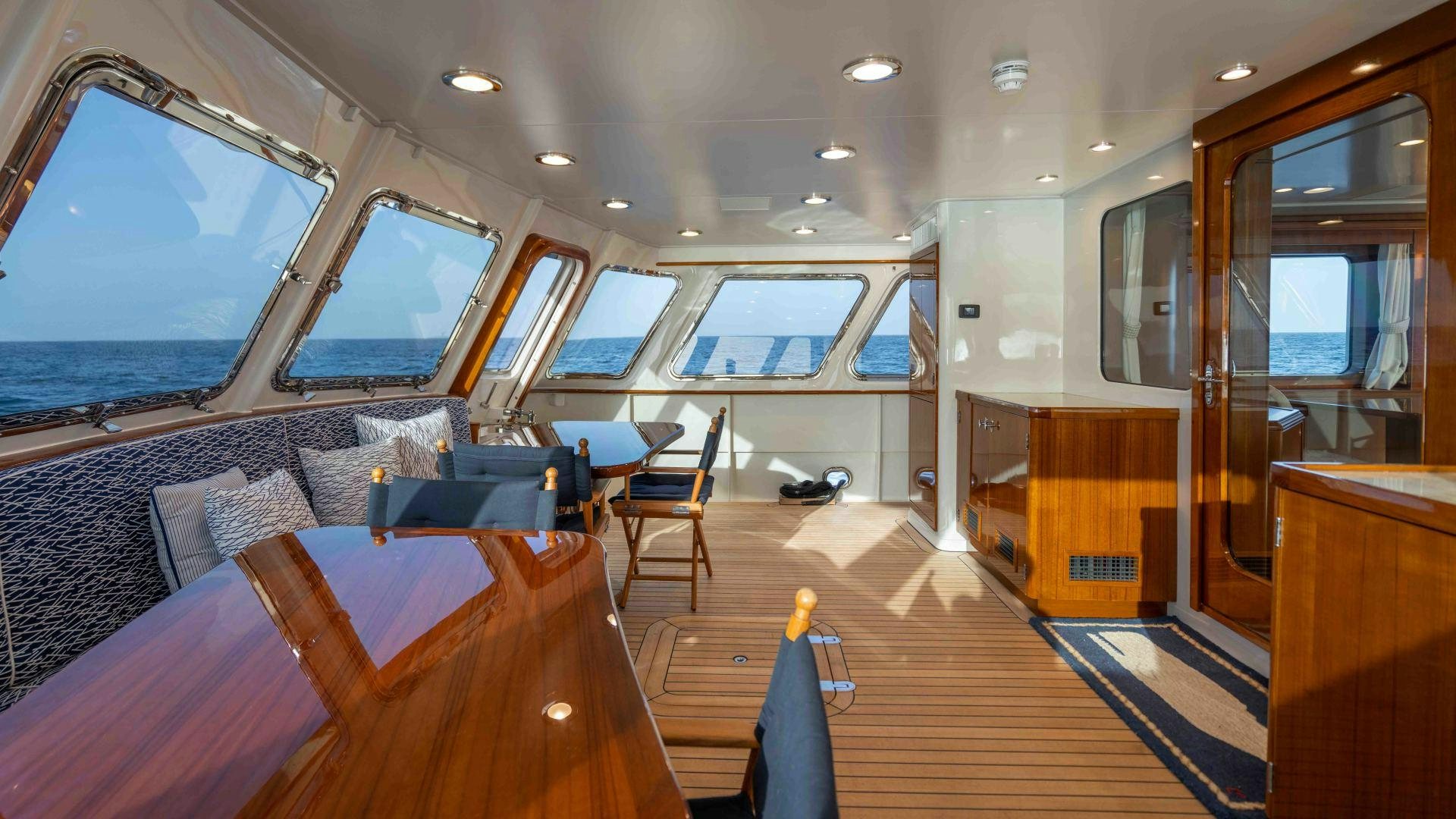 a room with a wood floor and a large window with a view of the water aboard NEREUS Yacht for Sale