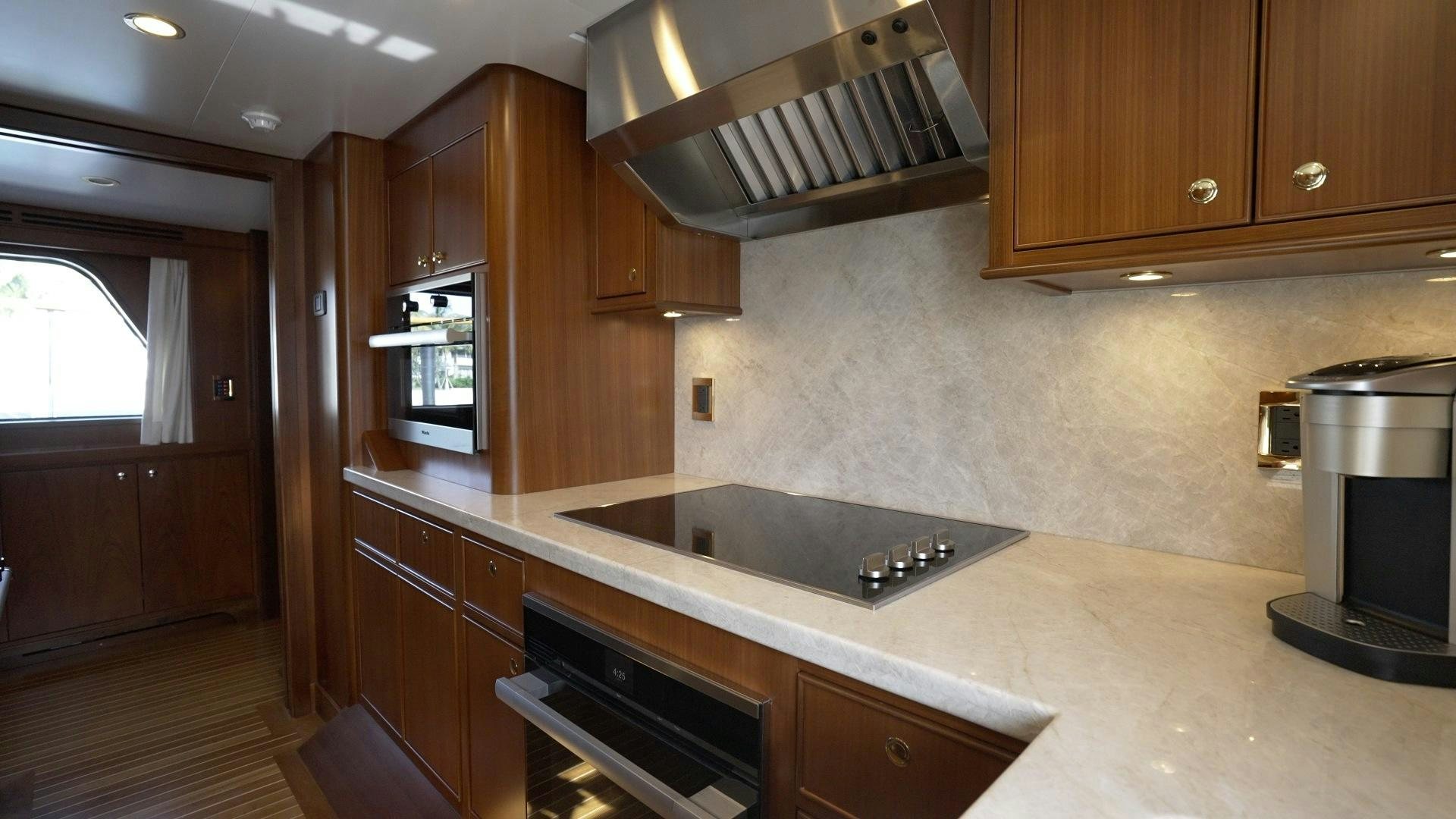 a kitchen with wooden cabinets aboard NEREUS Yacht for Sale
