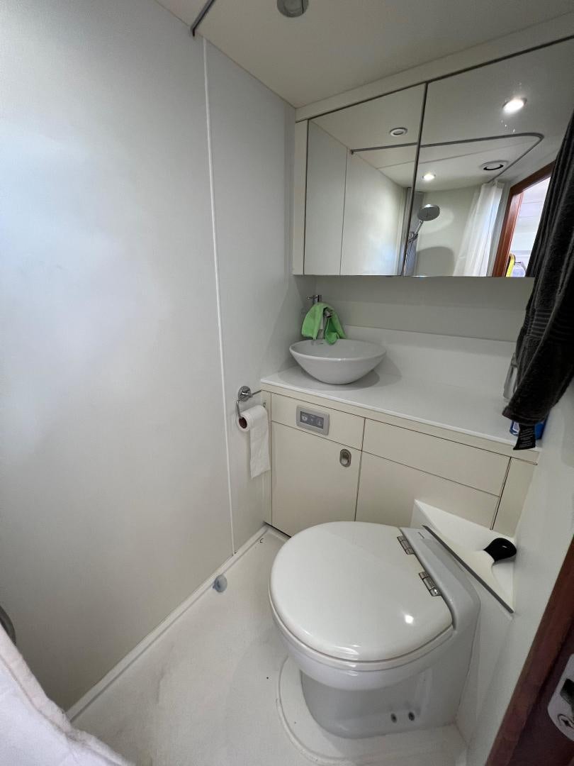 a bathroom with a toilet and a mirror aboard RAPALLO V Yacht for Sale