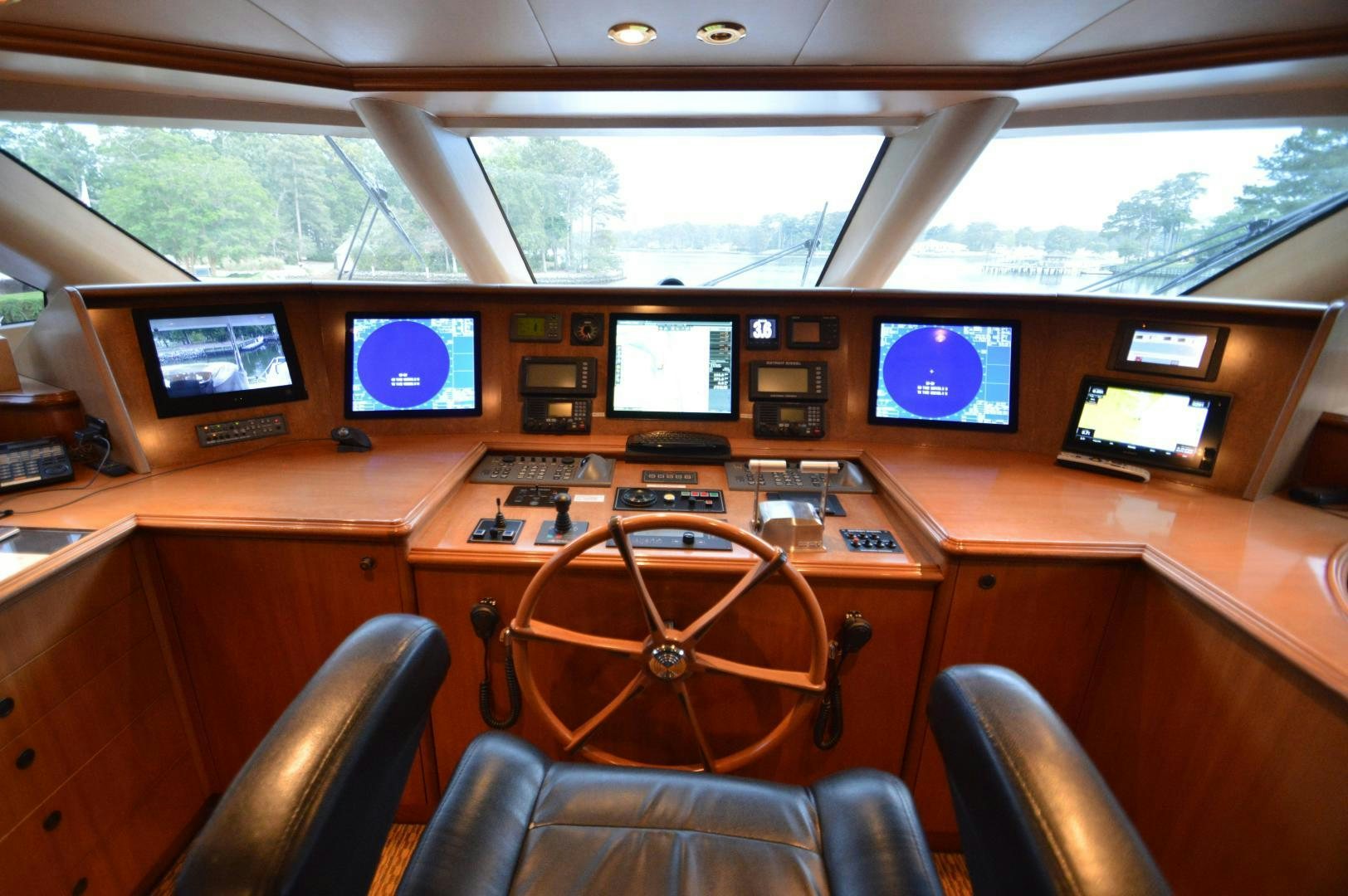 a wooden desk with a chair and computer screens aboard MARBRI Yacht for Sale