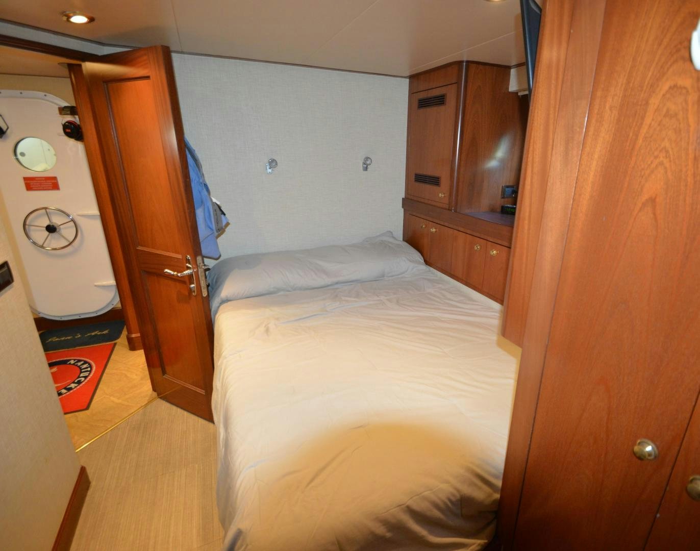 a bedroom with a bed and cabinets aboard MARBRI Yacht for Sale