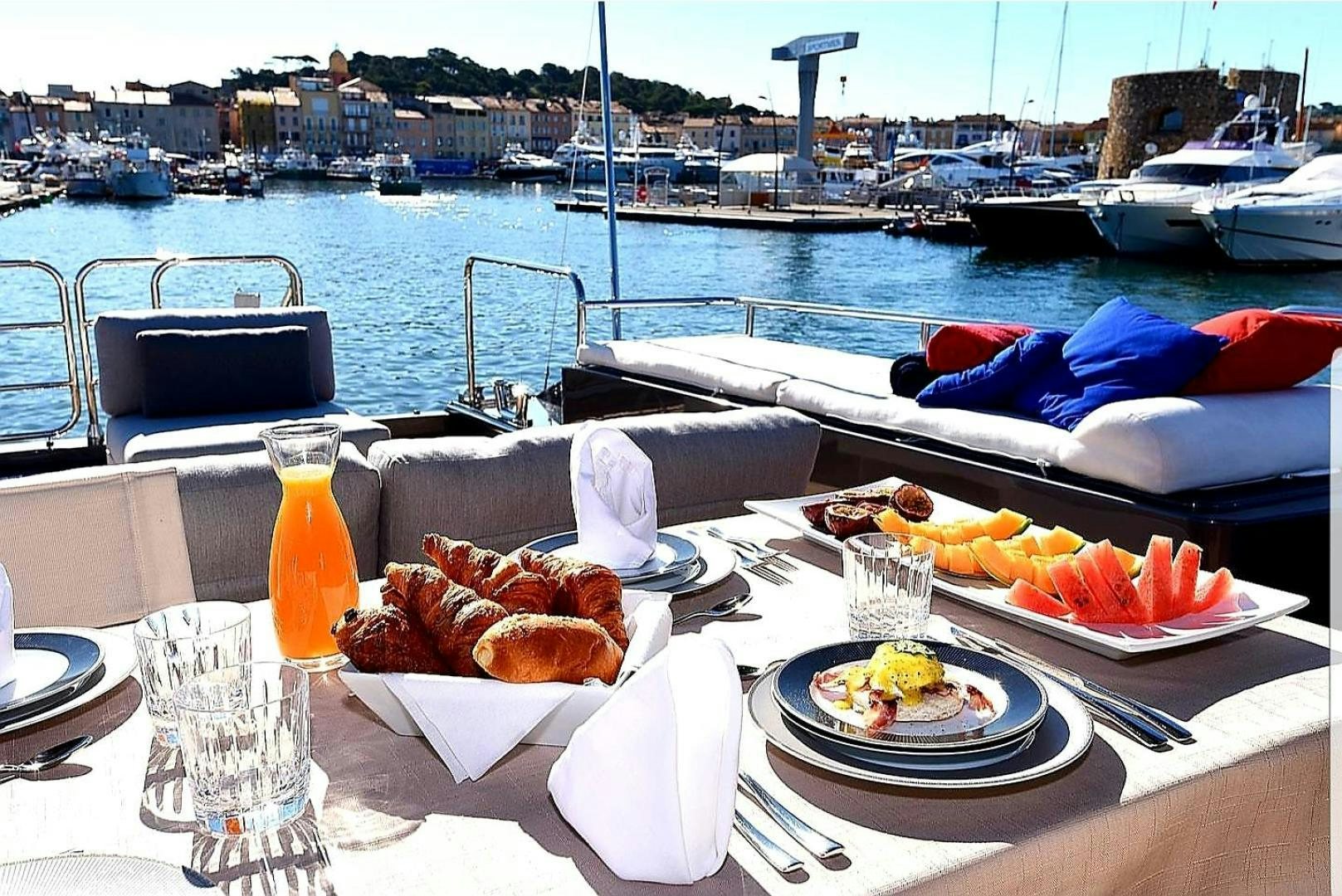a table with plates of food and drinks on it aboard OSE Yacht for Sale