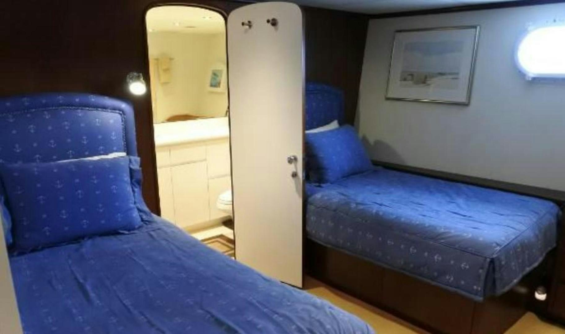 a room with a blue couch and a white door aboard MY LADY ALASKA Yacht for Sale