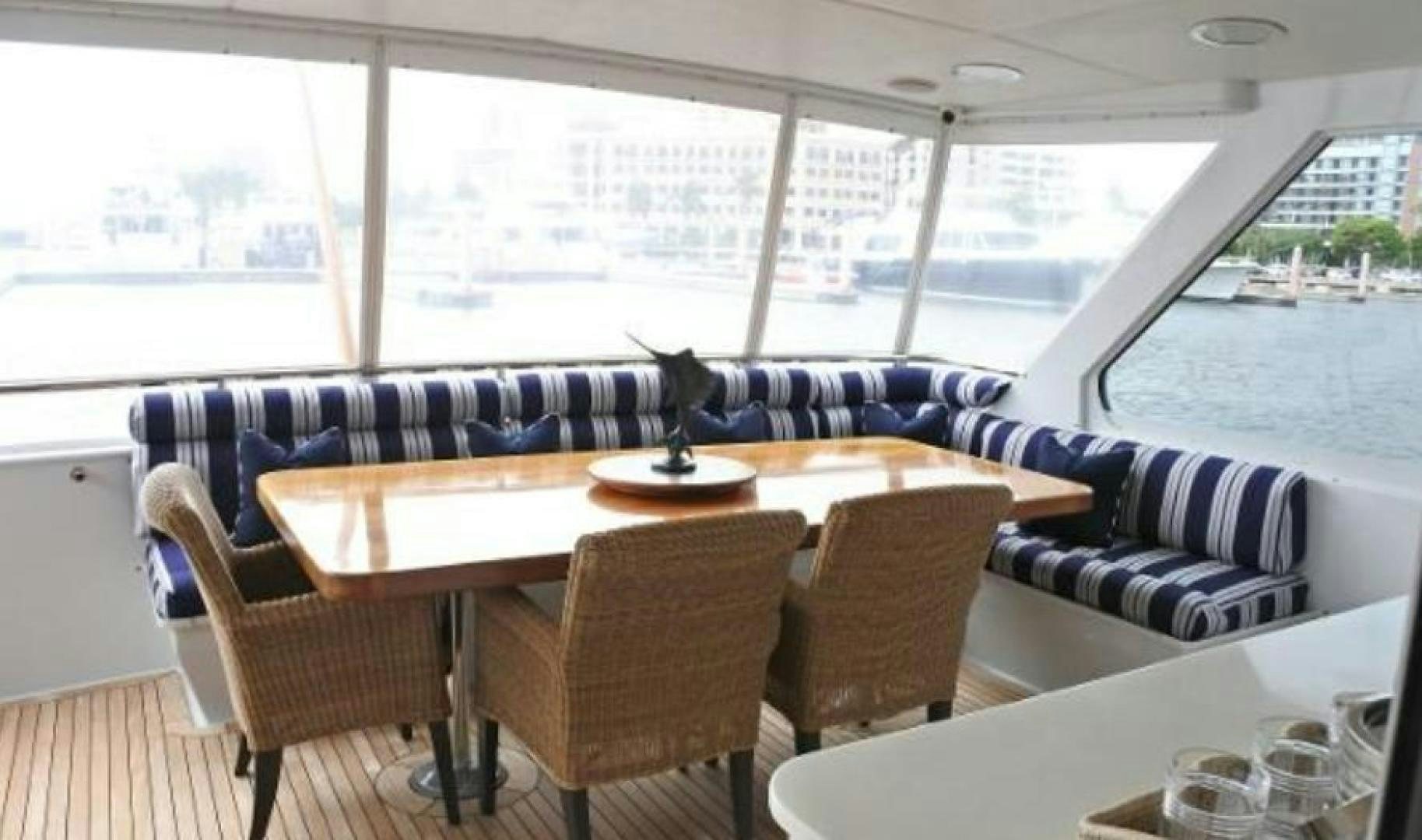 a table with chairs and a couch aboard MY LADY ALASKA Yacht for Sale