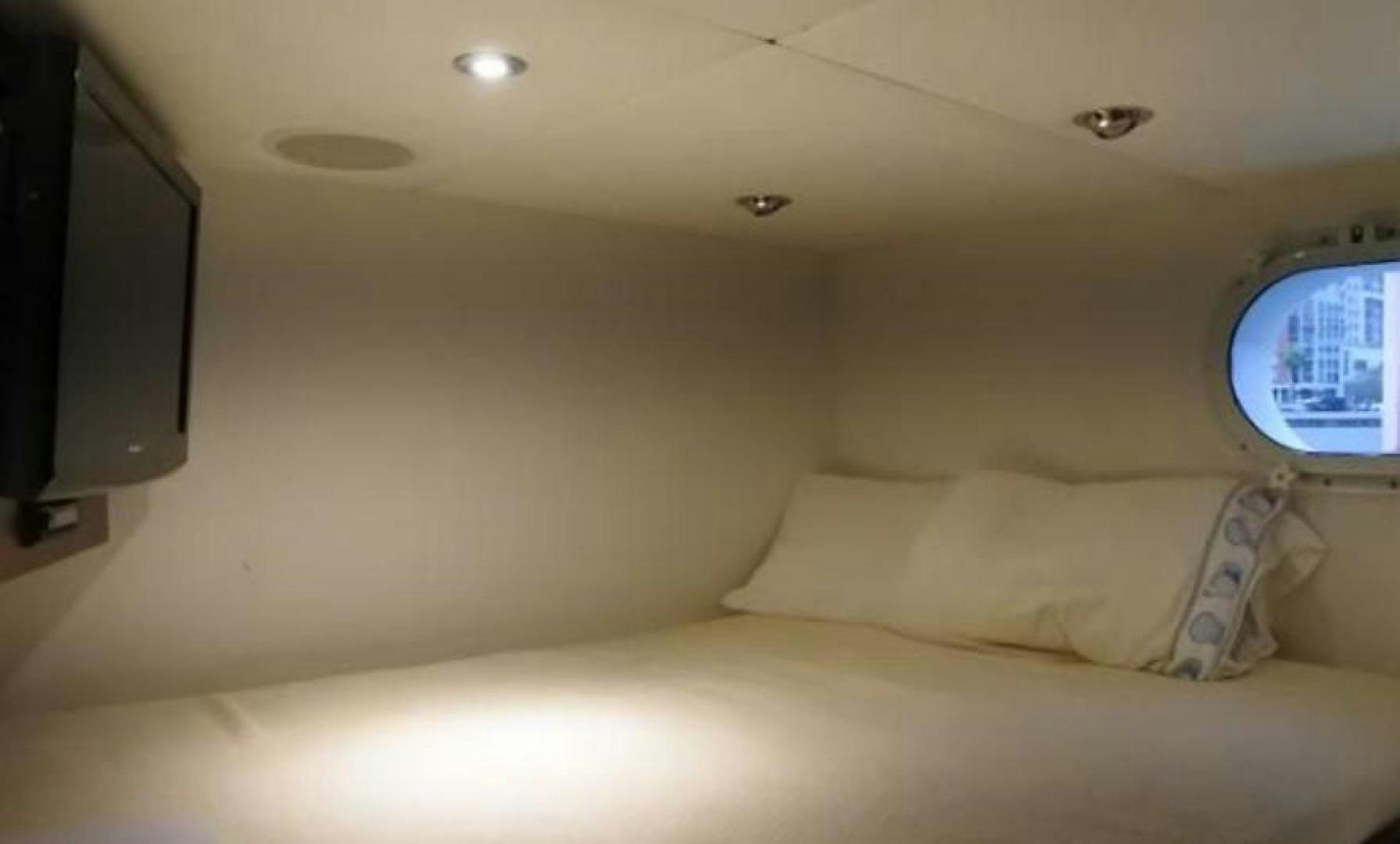 a bed with a television on the wall aboard MY LADY ALASKA Yacht for Sale