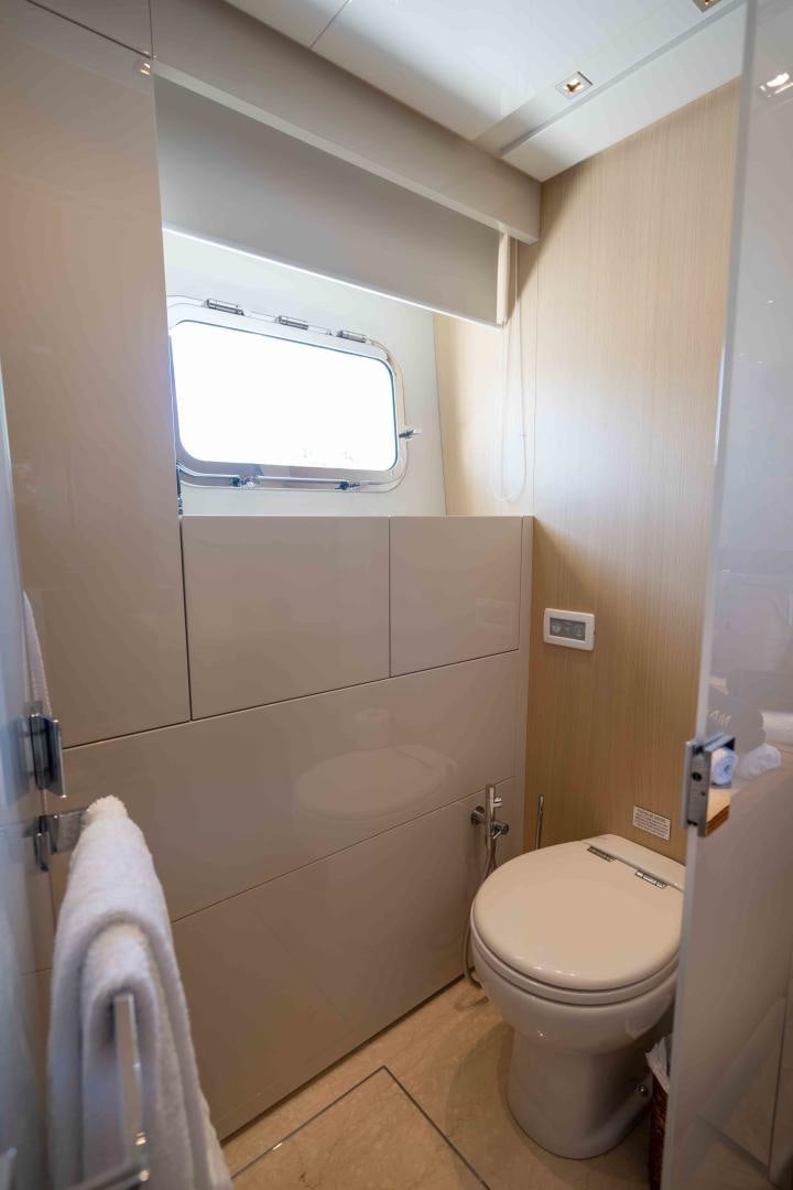 a bathroom with a toilet and a window aboard NOTORIOUS Yacht for Sale