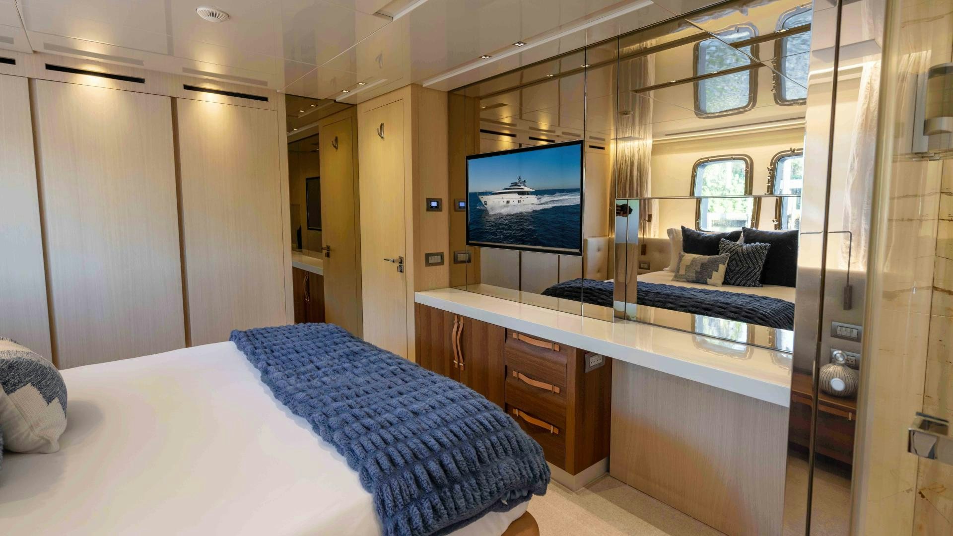 a room with a bed and a tv on the wall aboard NOTORIOUS Yacht for Sale