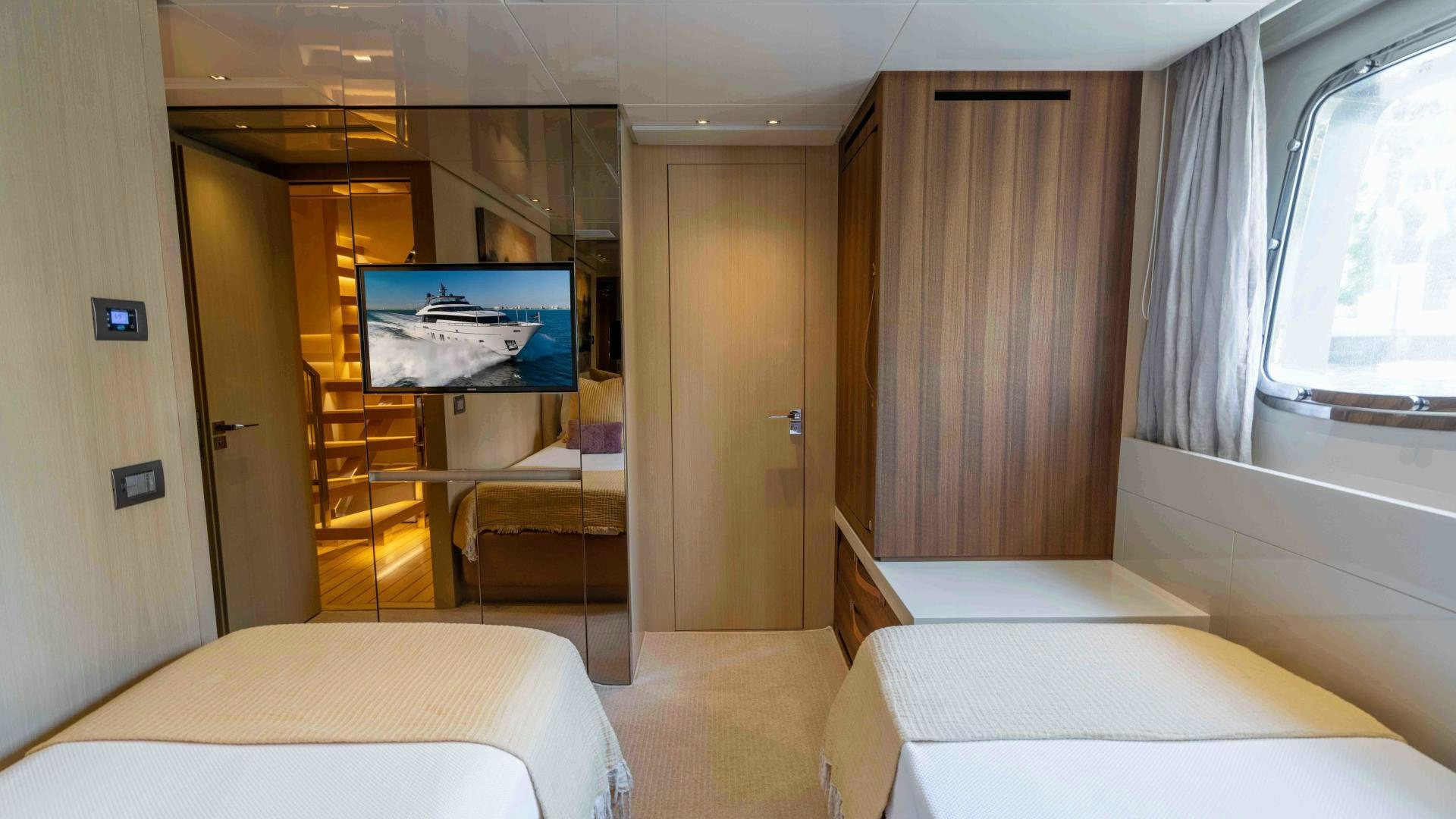 a room with a bed and a tv on the wall aboard NOTORIOUS Yacht for Sale