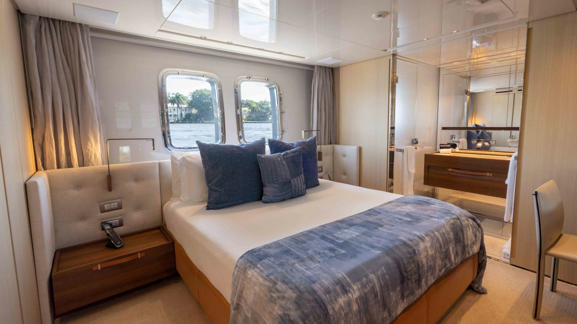 a bedroom with a bed and a dresser aboard NOTORIOUS Yacht for Sale