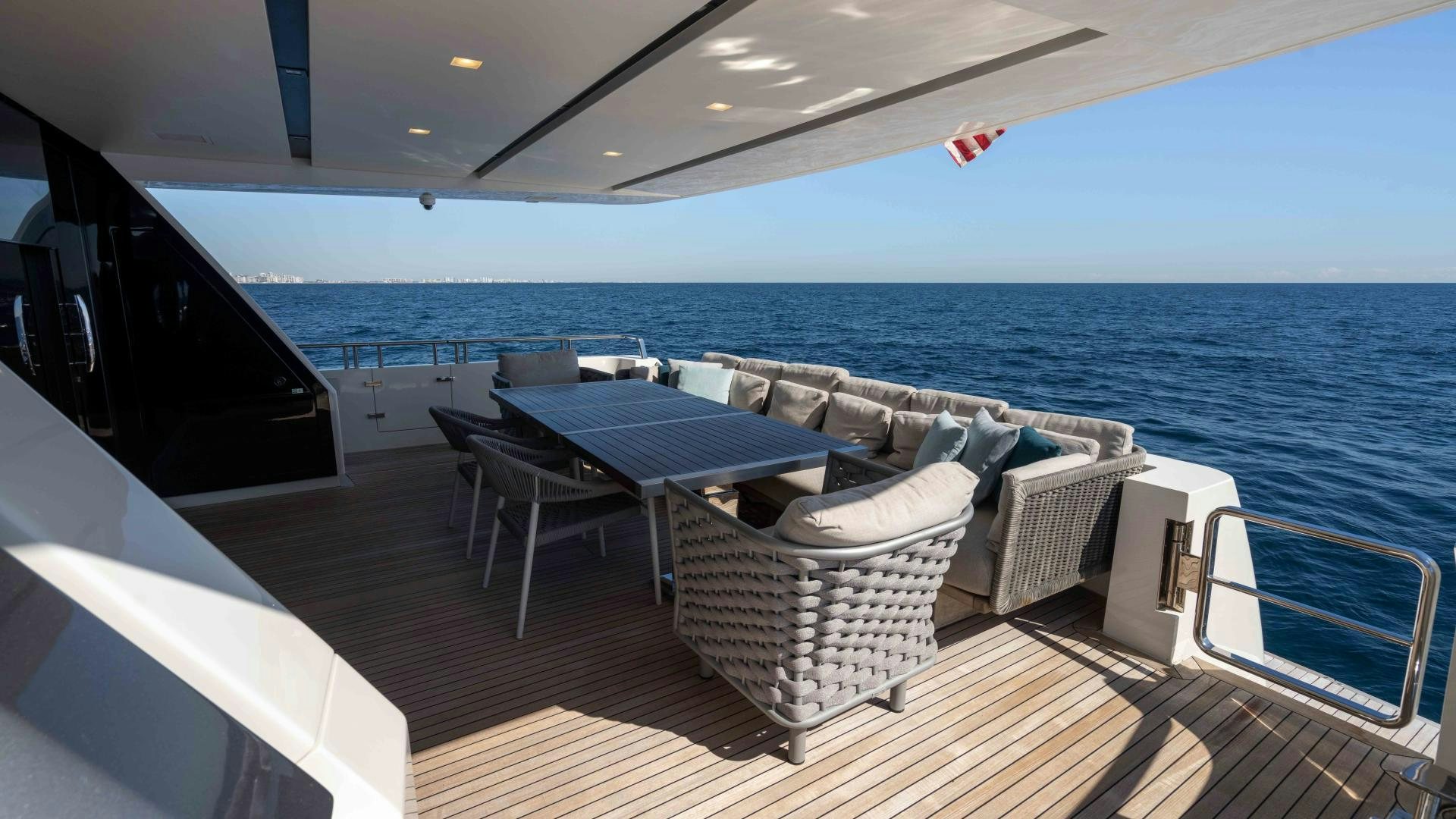 a deck with chairs and a table on it aboard NOTORIOUS Yacht for Sale