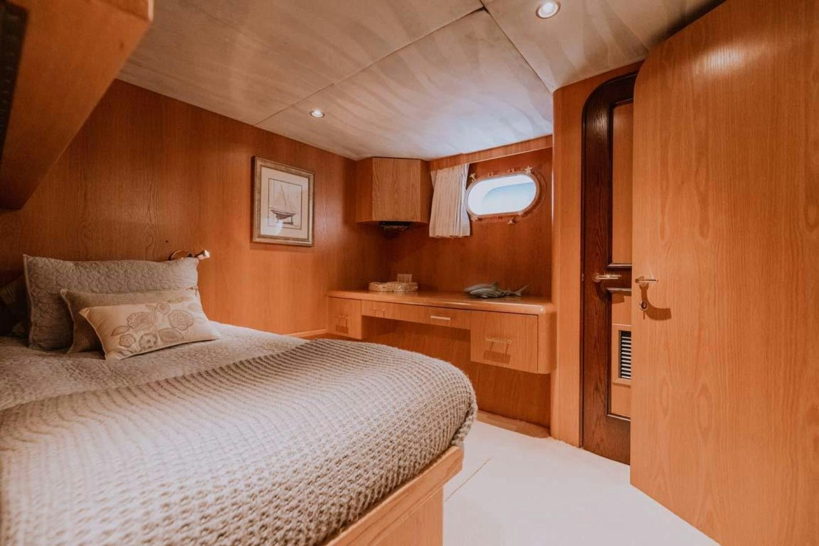 a bedroom with a bed and a desk aboard SKY Yacht for Sale