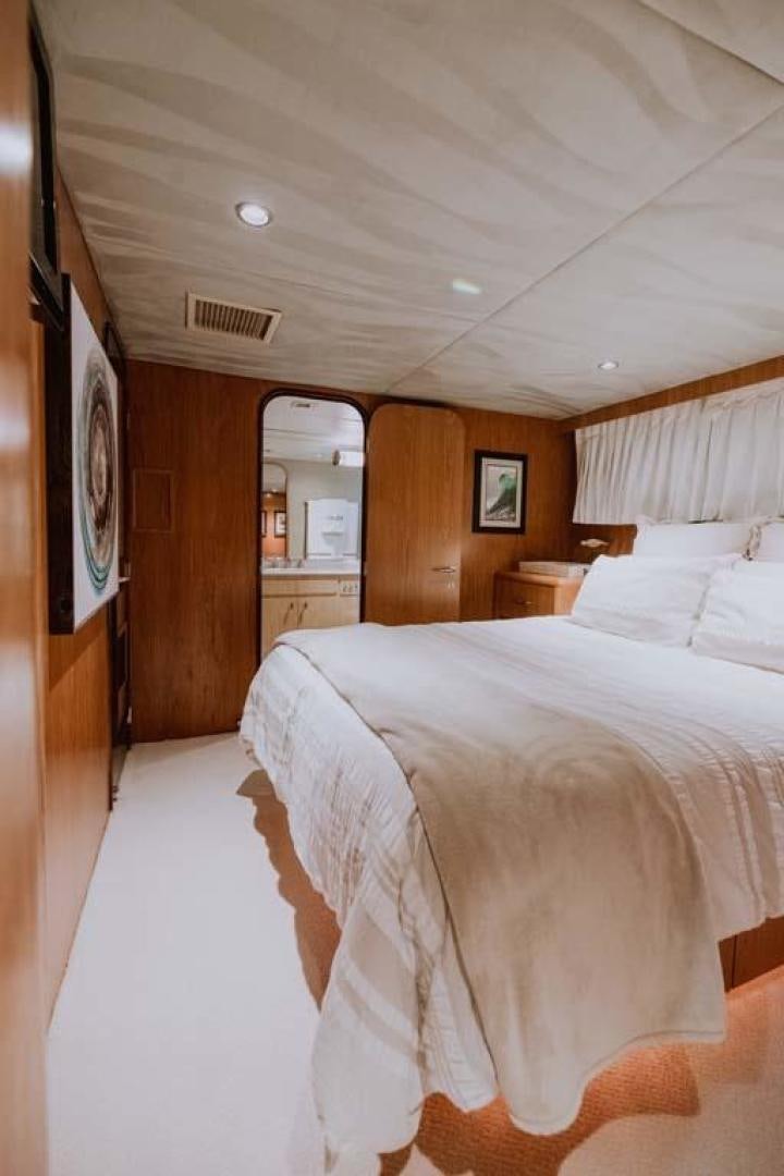 a bedroom with a bed and a mirror aboard SKY Yacht for Sale