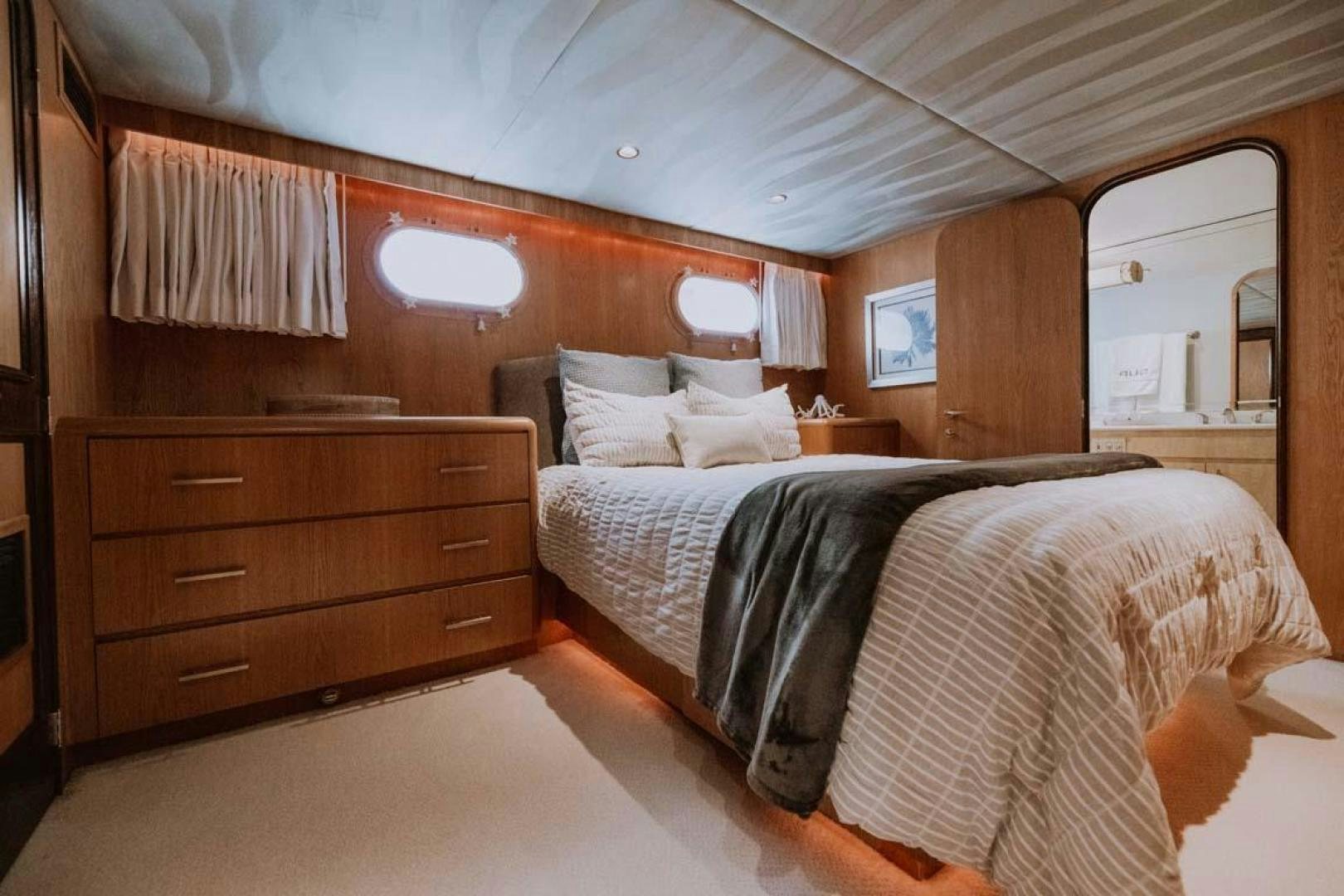 a bedroom with a bed and a dresser aboard SKY Yacht for Sale