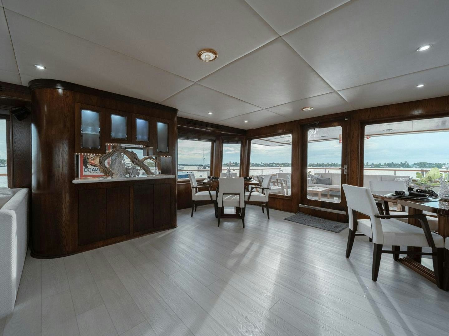 a room with a wood cabinet and chairs and a large window aboard SKY Yacht for Sale