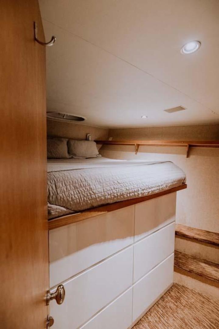 a bed with white drawers aboard SKY Yacht for Sale