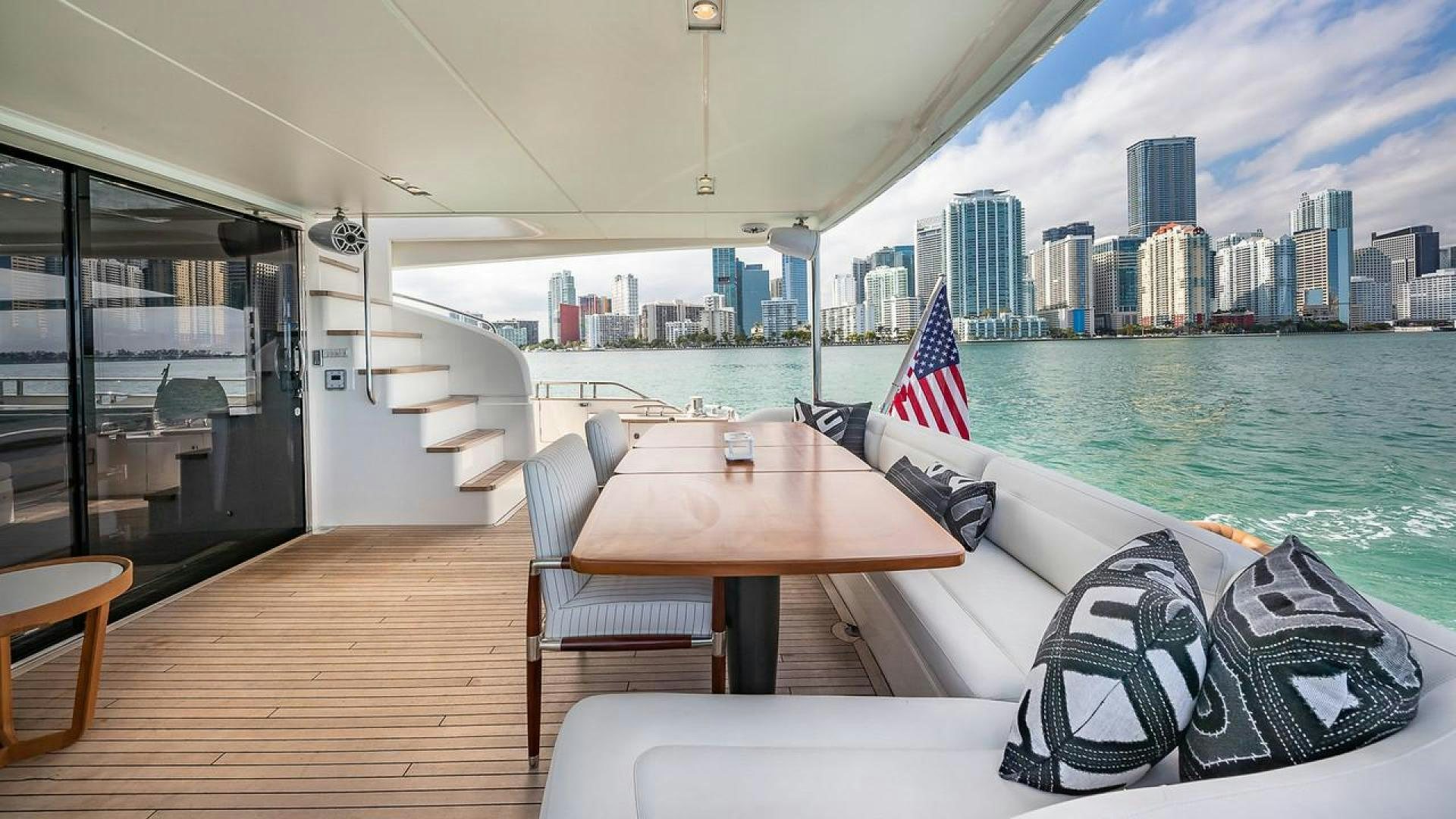 a table and chairs on a deck overlooking a city aboard FREEDOM Yacht for Sale