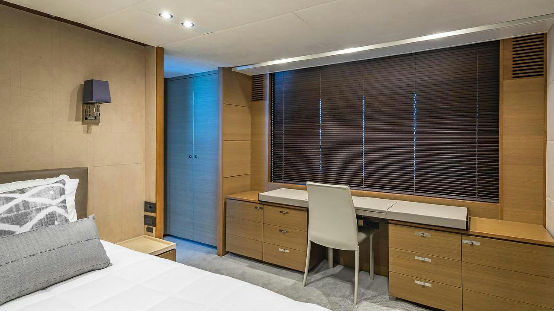 a room with a bed and desk aboard FREEDOM Yacht for Sale