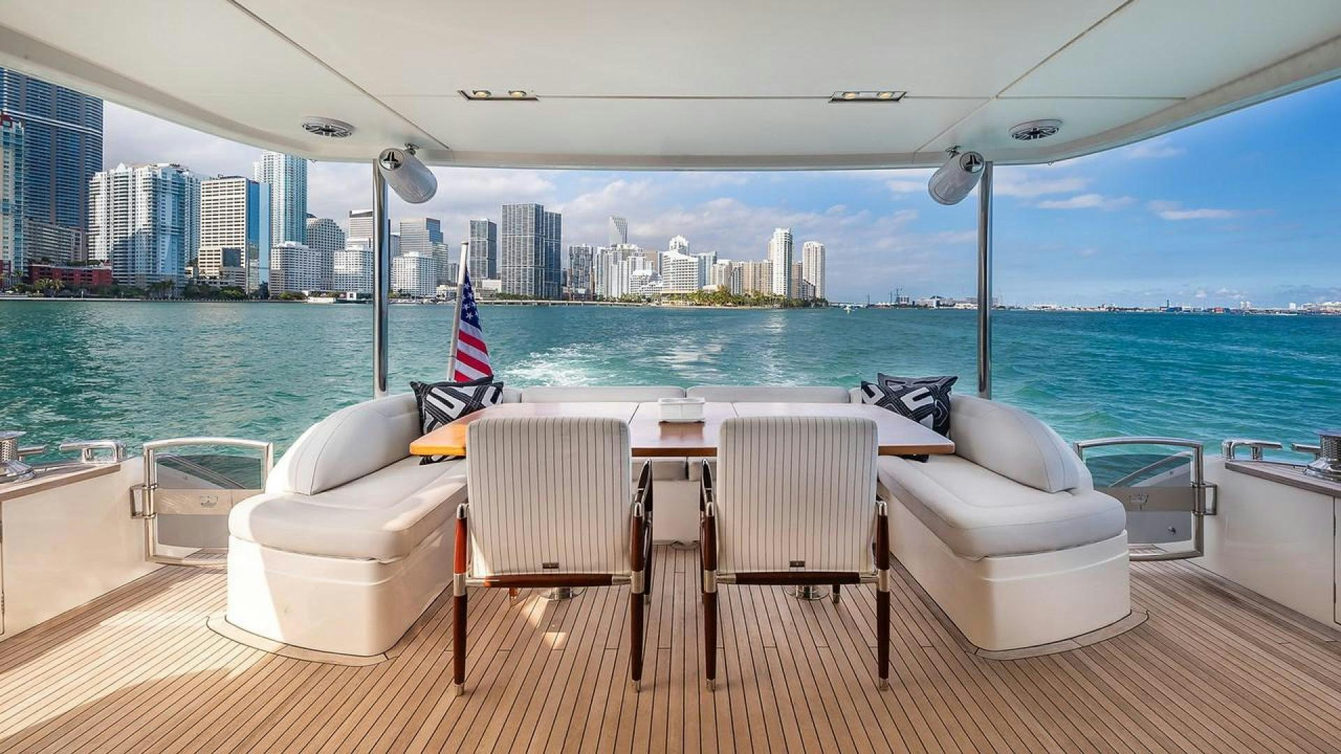 a deck with chairs and a table on it aboard FREEDOM Yacht for Sale