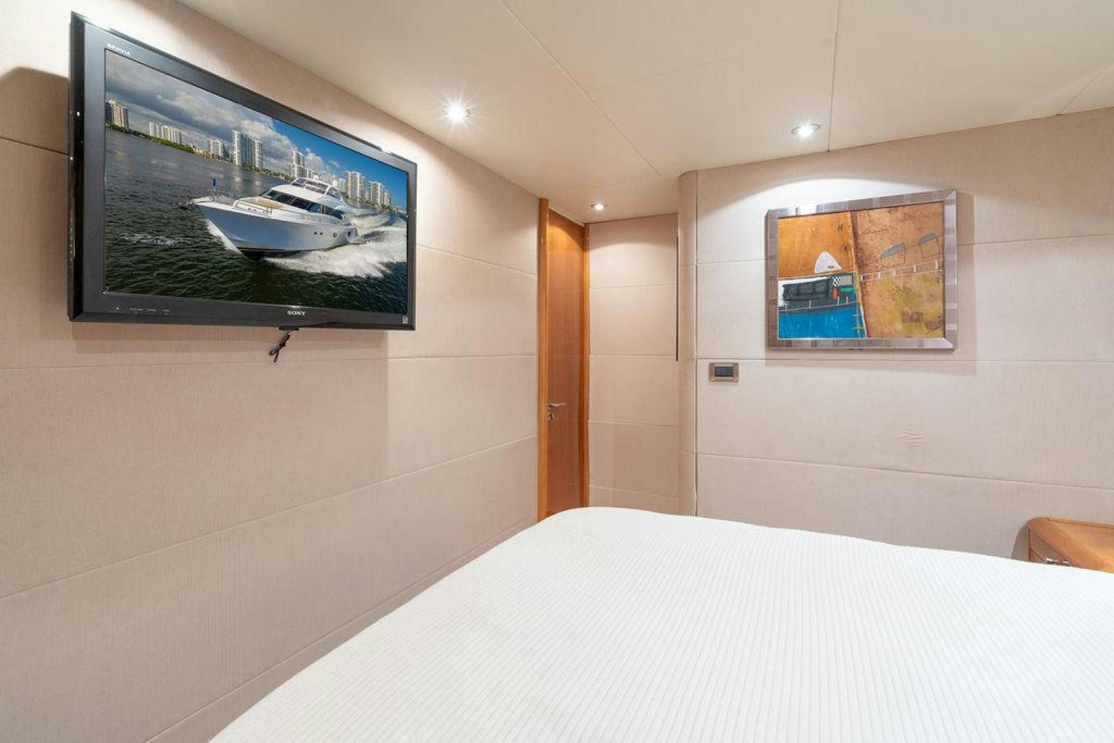 a room with a bed and a television on the wall aboard CHIP Yacht for Sale