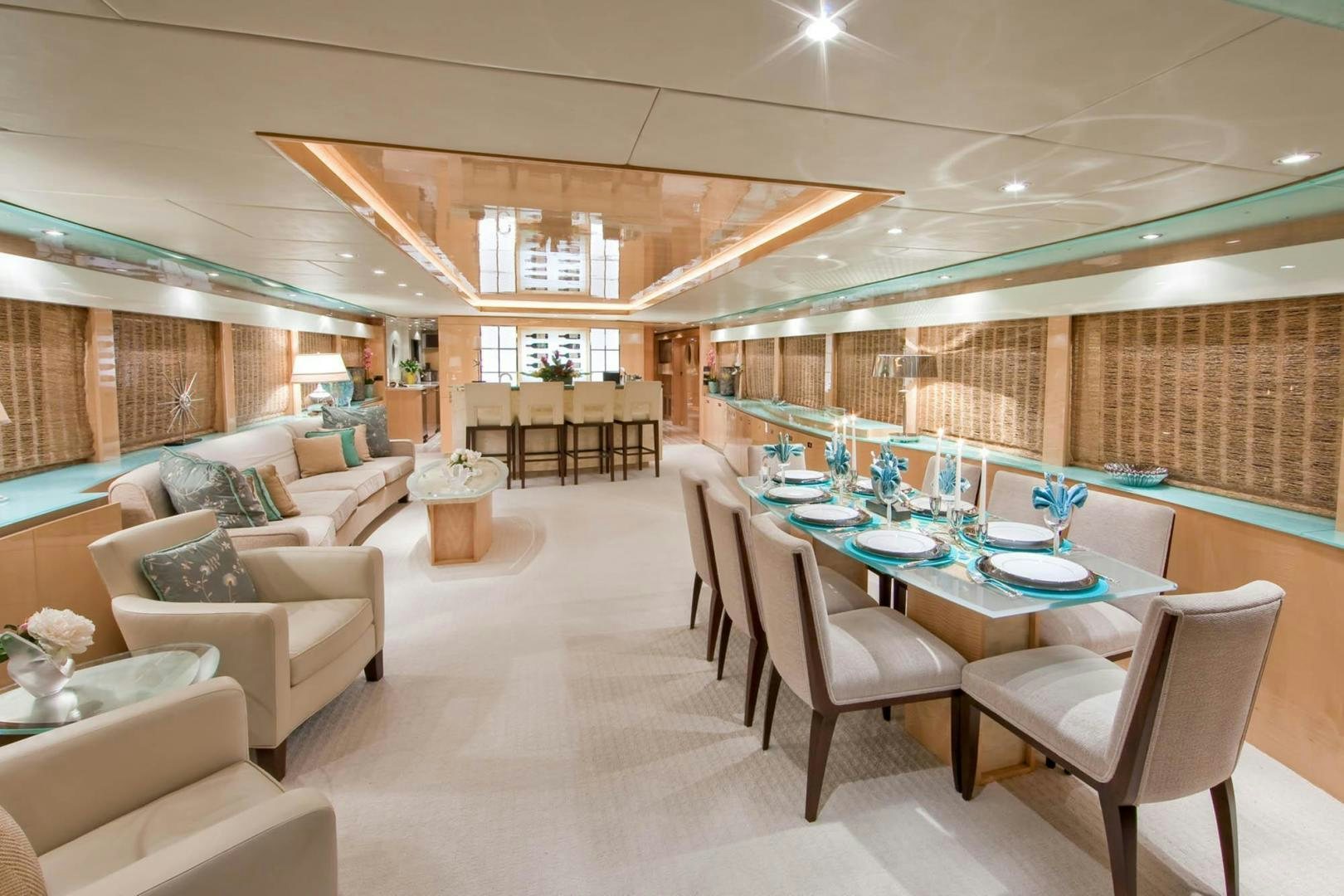a room with a table chairs and a couch aboard INCEPTION Yacht for Sale